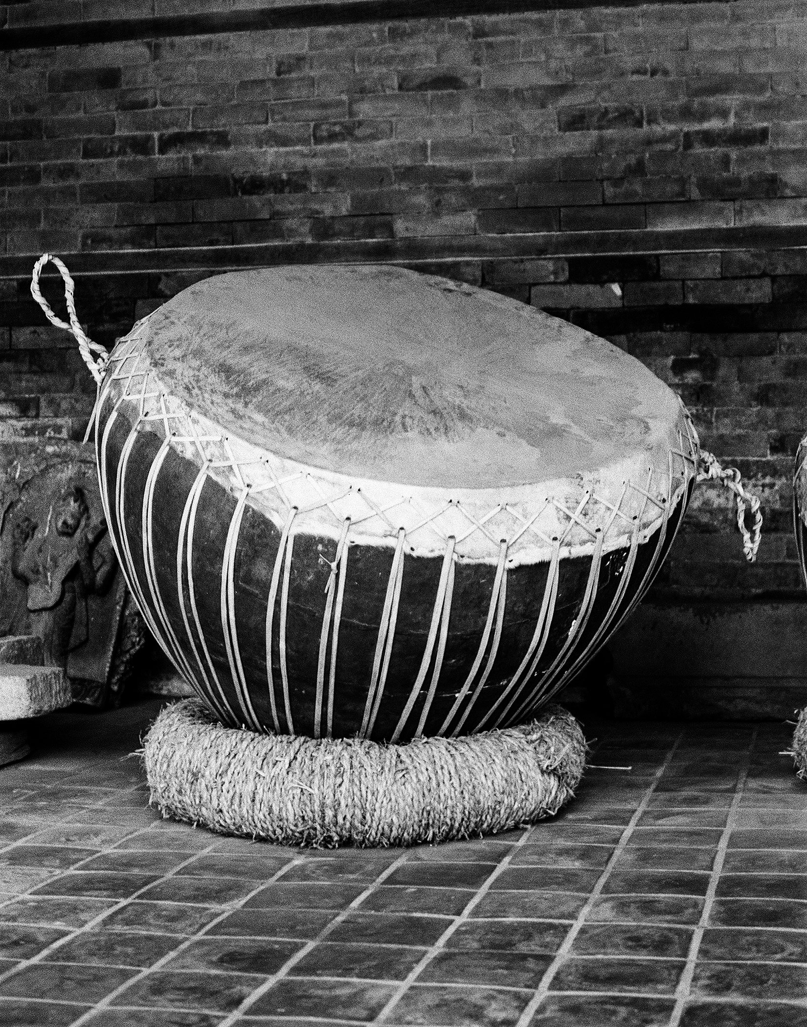 Traditional handcrafted drum with decorative rope binding and curved surface