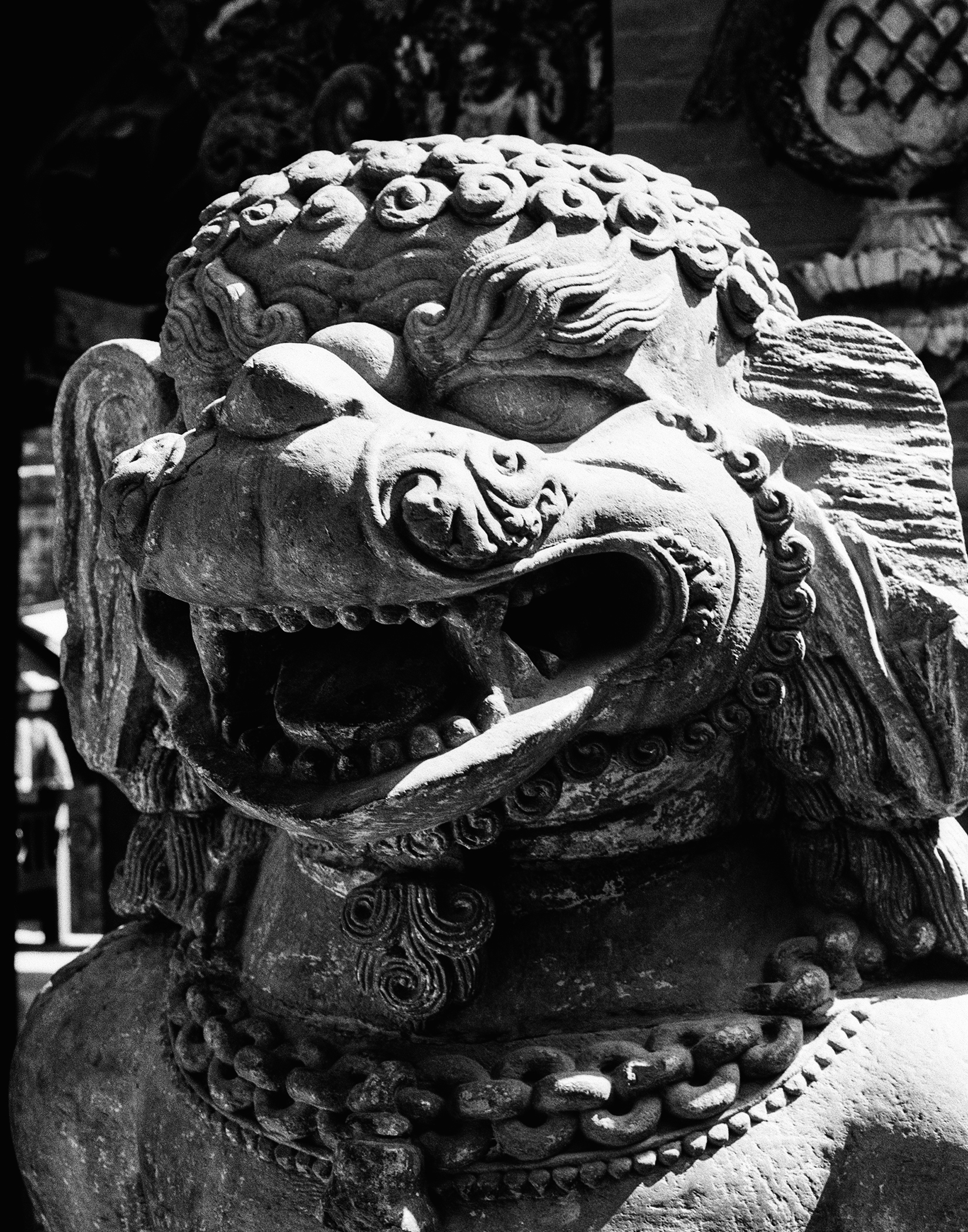 Ornate carved stone or wooden dragon sculpture with intricate details and fierce expression