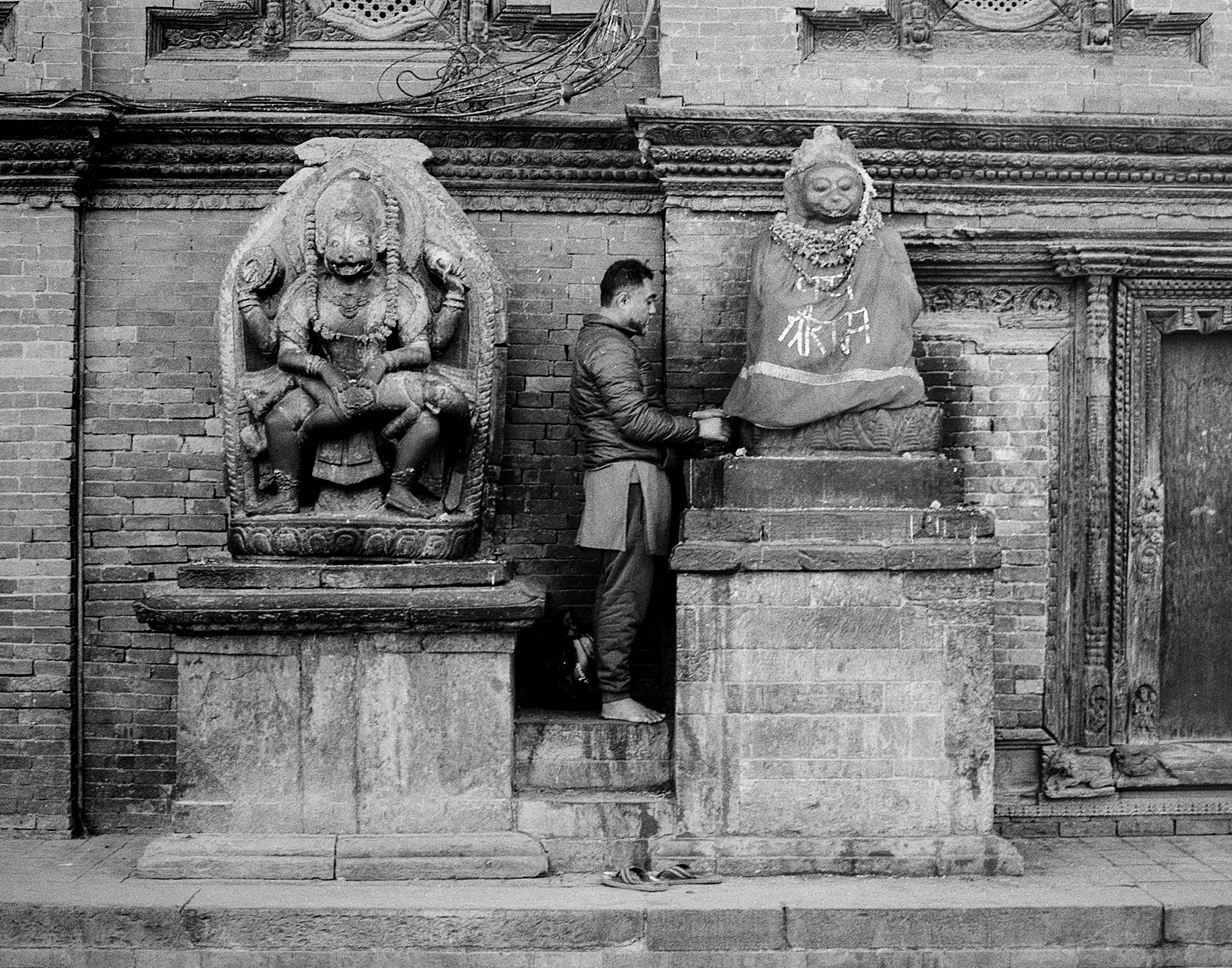 Ornate carved temple relief featuring female deity and male figure with traditional garments