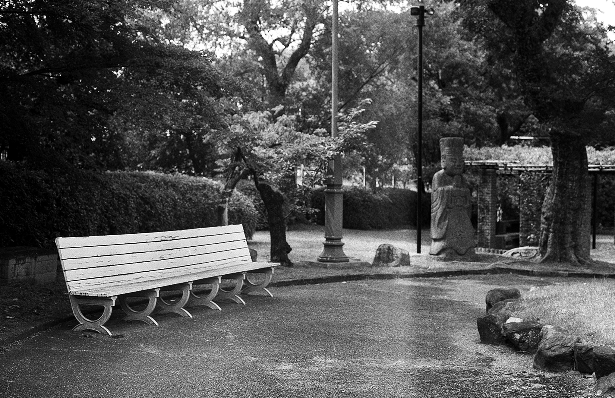 Memorial cemetery garden scene with benches stone monuments crosses and mature trees creating contemplative space