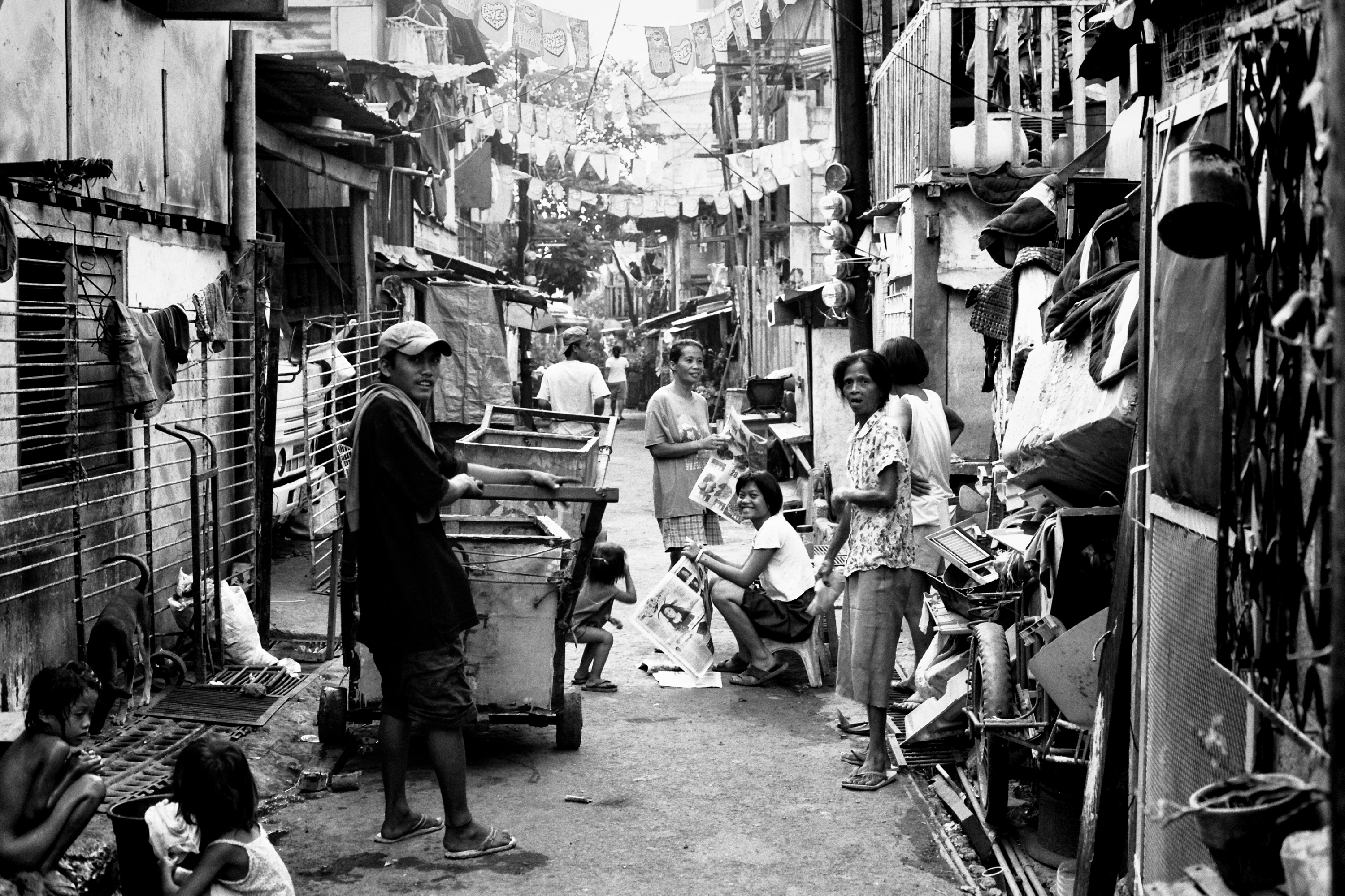 Bustling narrow alley street scene with multiple people vendors laundry and dense urban neighborhood daily life