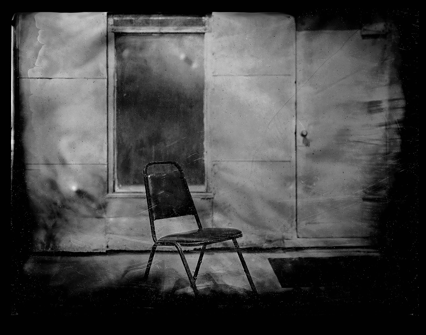 Stark minimalist collodion composition of solitary metal chair positioned against tall windows in weathered interior space with dramatic natural light and geometric lines