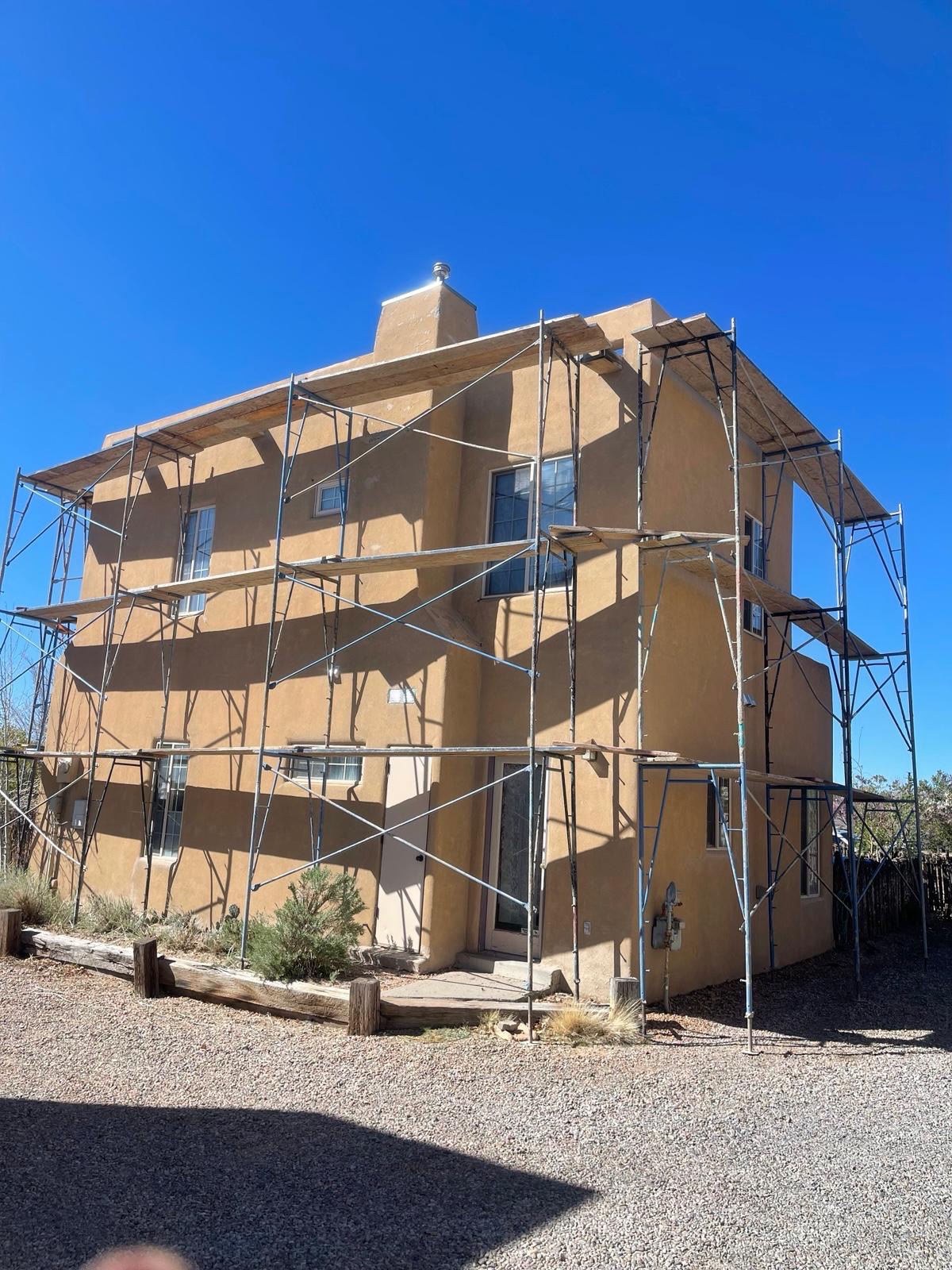 Two-story Southwest adobe home with exterior stucco work in progress