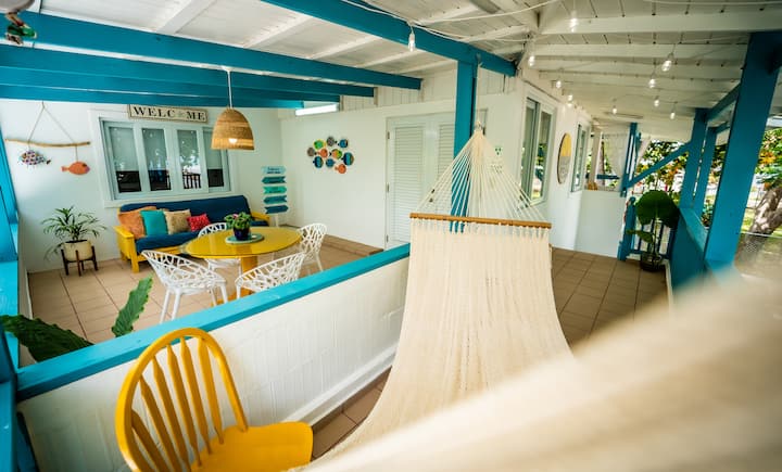 Open terrace with hammock, yellow chairs, blue sofa and Welcome sign