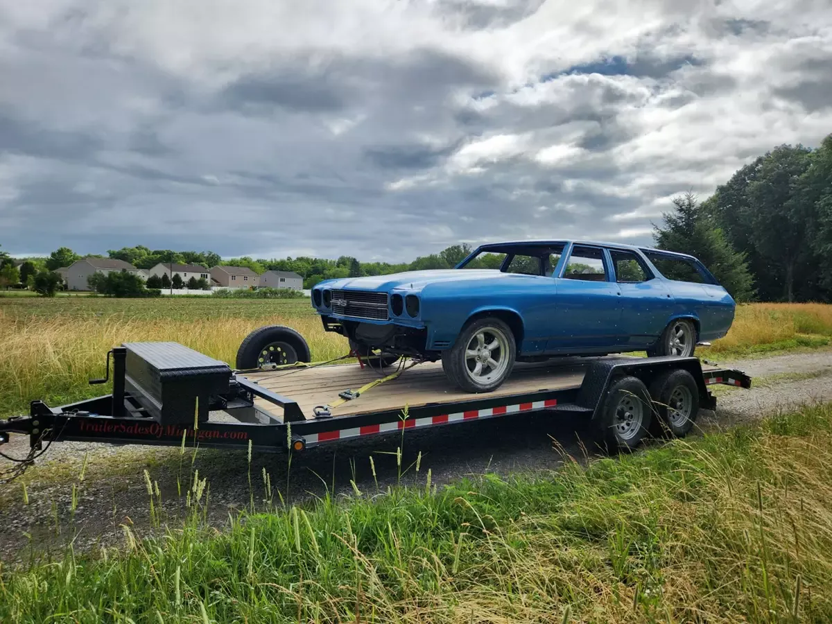 Classic car on car hauler trailer in a field