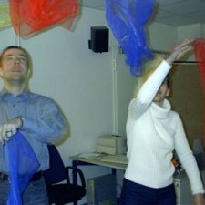 Mann und Frau jonglieren bunte Tücher im Innenraum