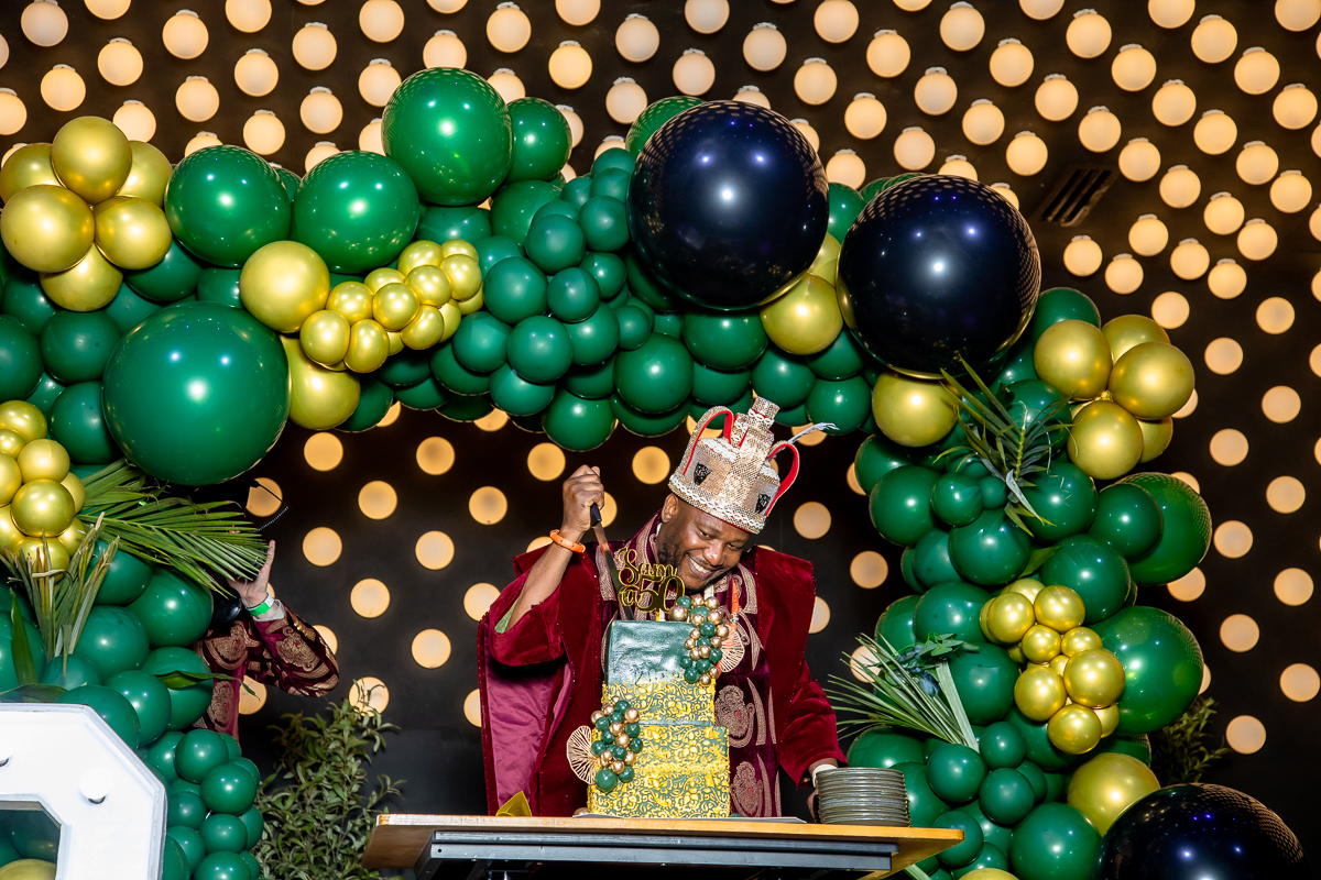 Sam at celebration with balloon backdrop