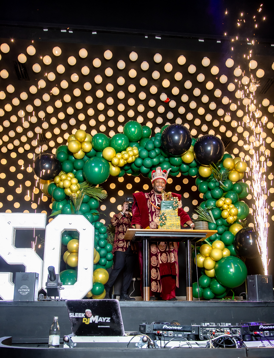 Sam on stage with 50 sign