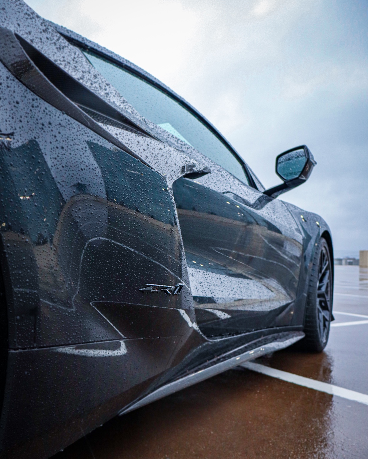 Close-up detail shot of black C8 Corvette ZR1 side scoop with rain droplets