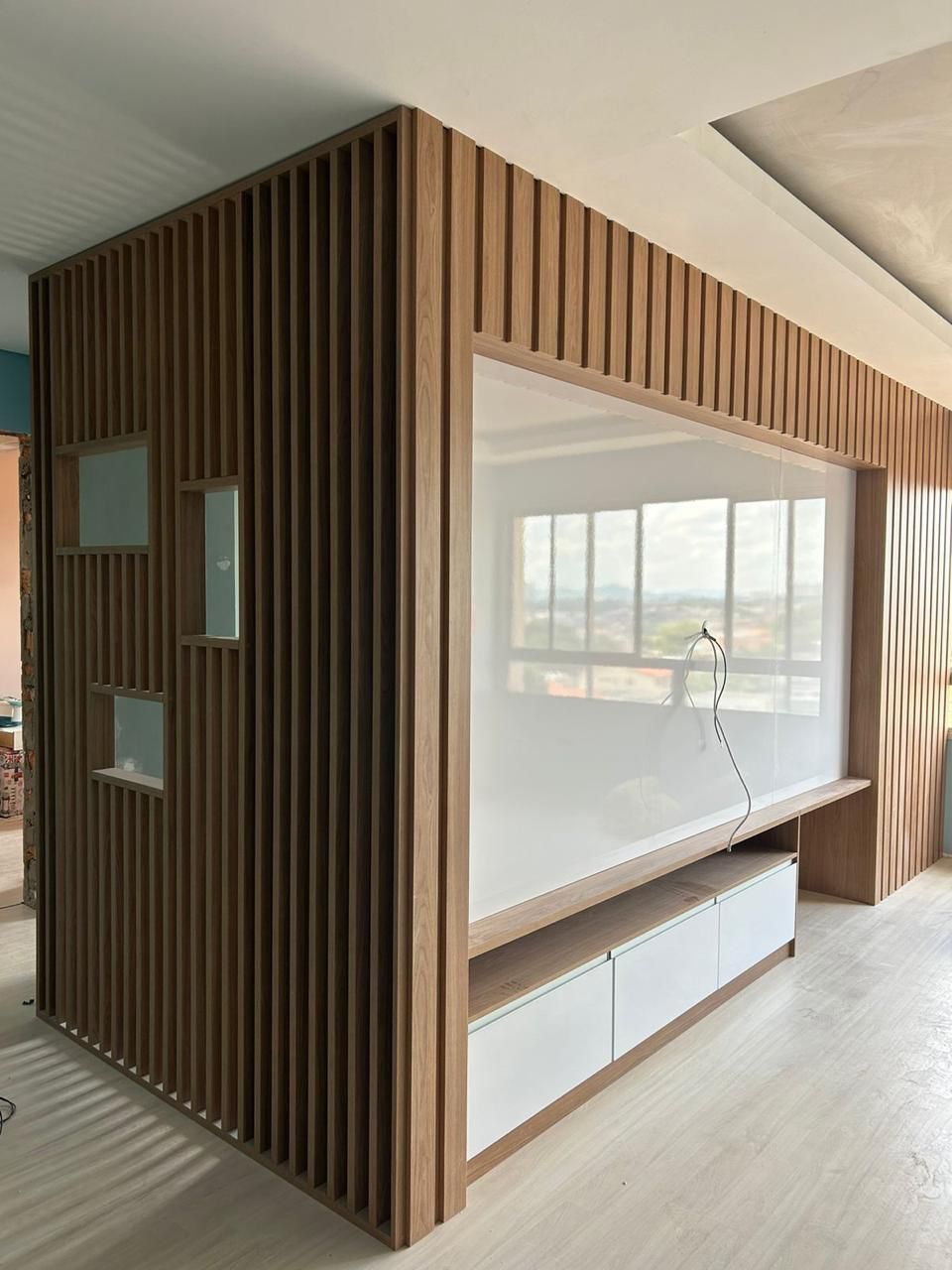 Painel de TV com ripado de madeira e gavetas brancas