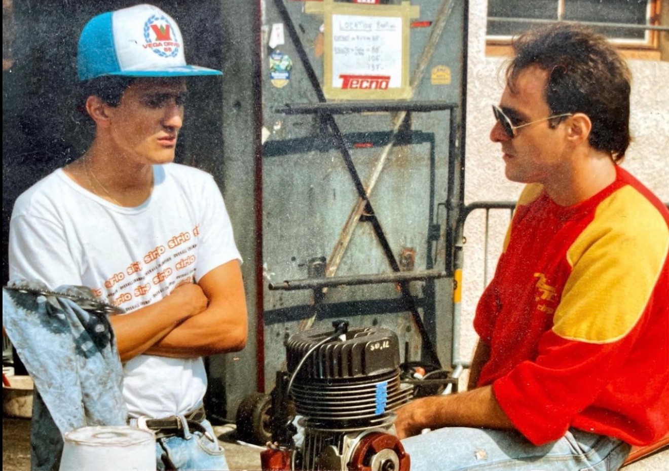 Christian Boudon coaching a young driver in the paddock workshop