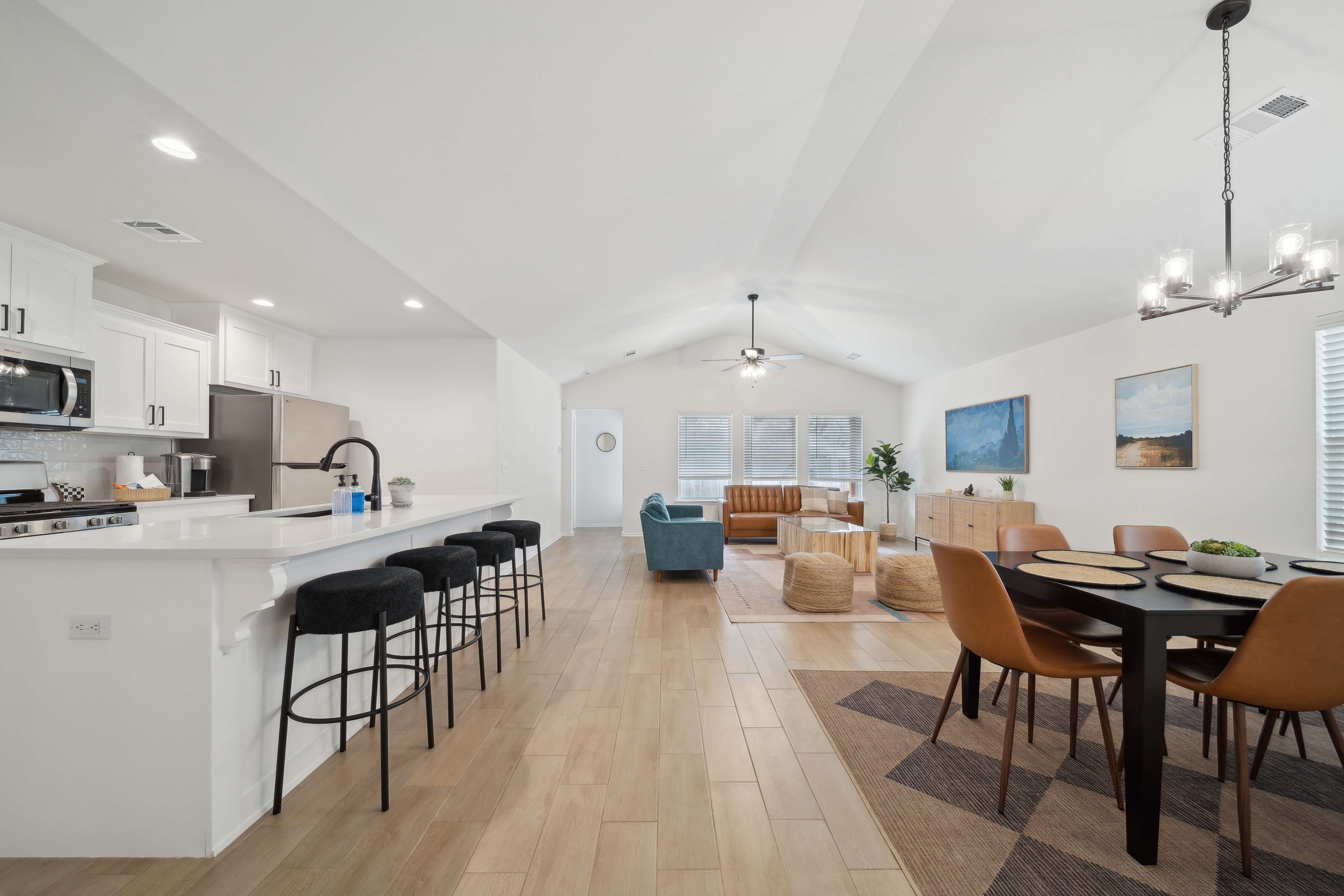 Open concept living, dining, and kitchen with vaulted ceilings