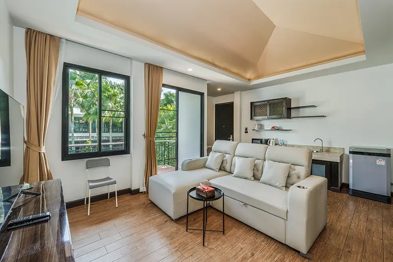 Salon z białą sofą i aneksem kuchennym