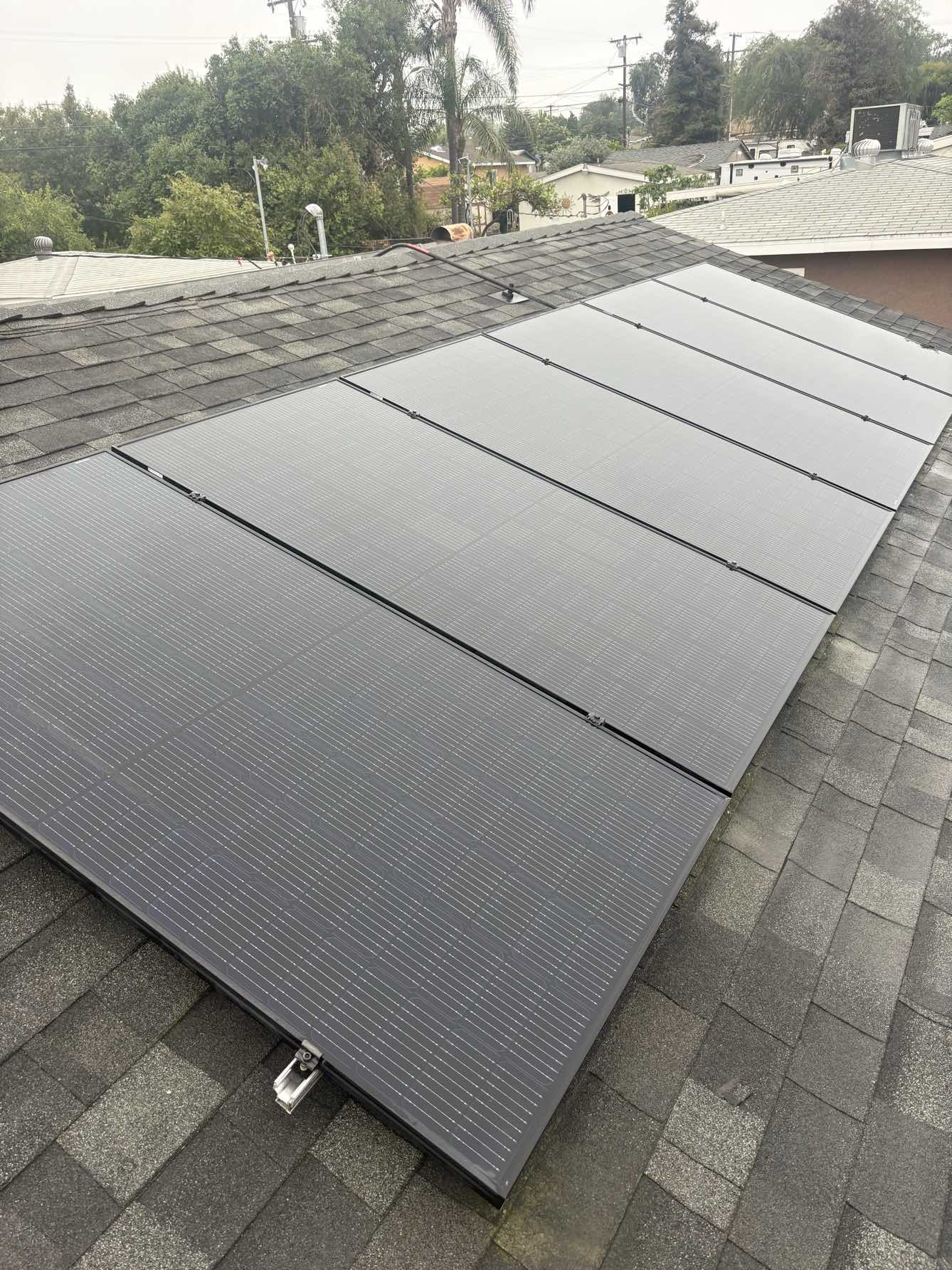 Clean solar panels on gray shingle roof