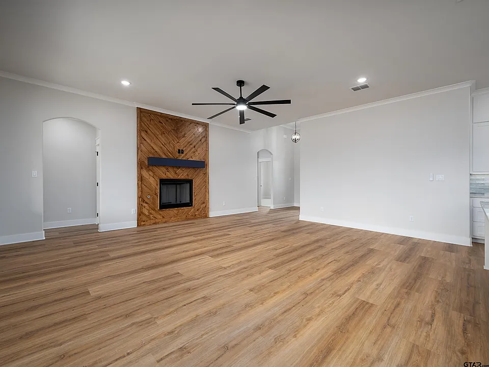 Great room with wood chevron fireplace and arched niches