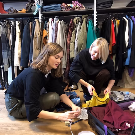 Two women sorting clothes on the floor of a MARTA store