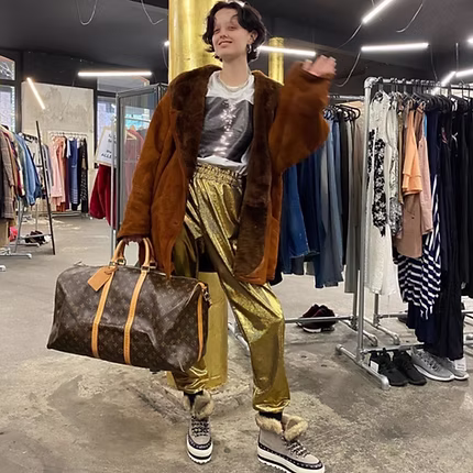 Woman smiling while browsing clothes on a rack