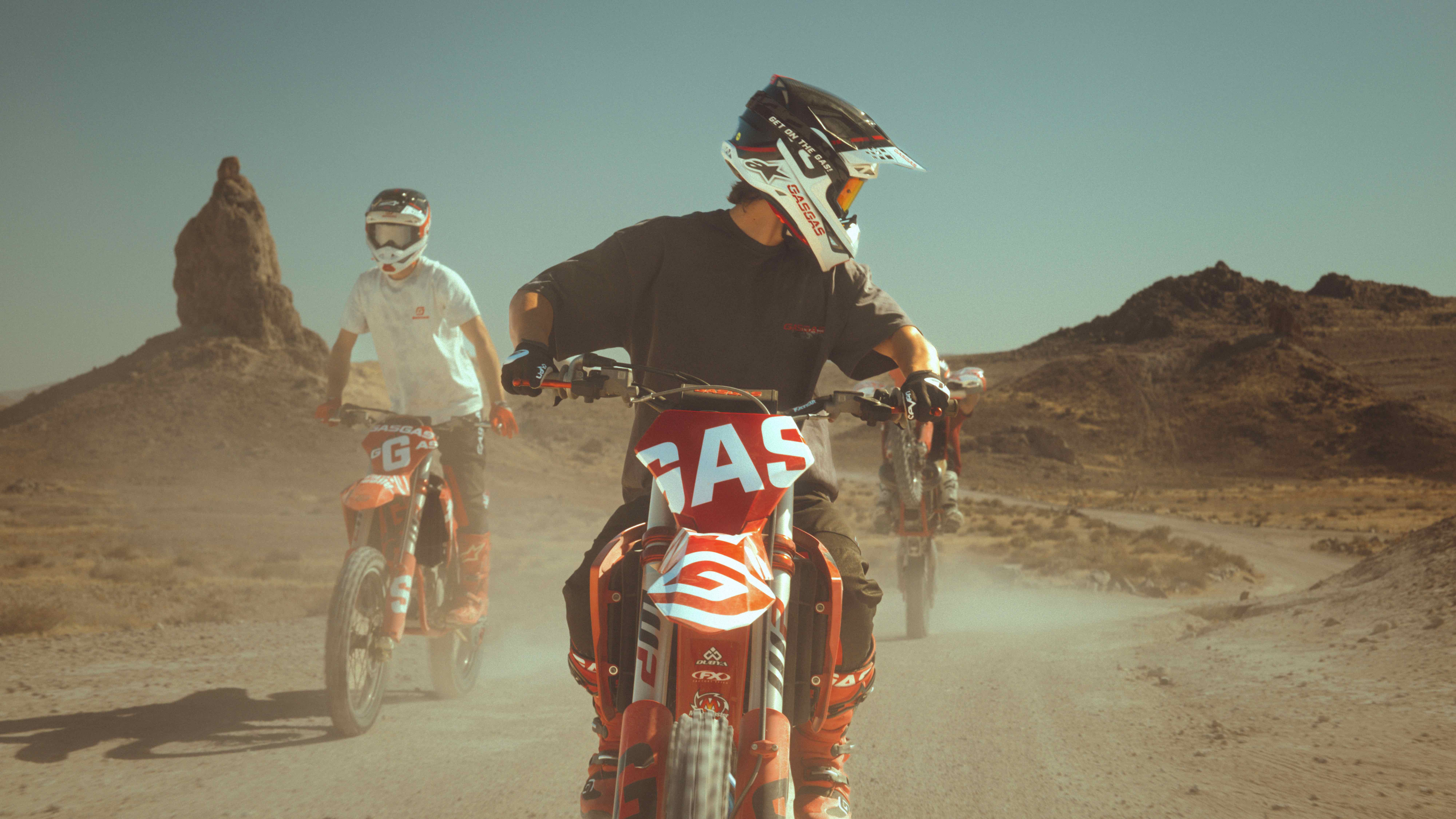 GASGAS riders charging toward the camera on a dusty desert trail