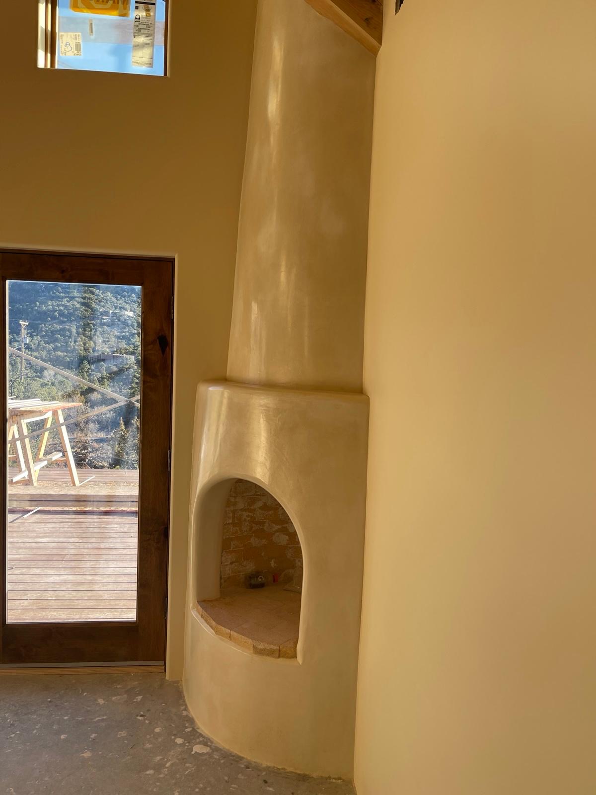Interior kiva fireplace with smooth cream plaster finish