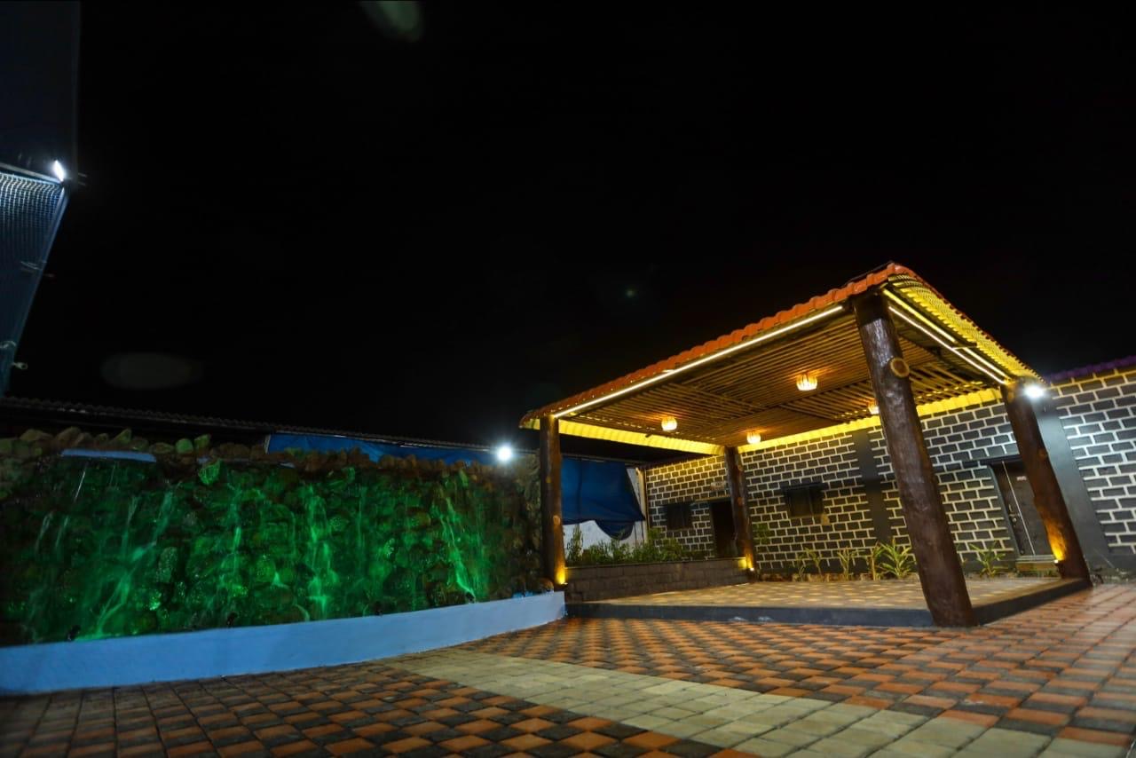 Illuminated waterfall and treehouse-style outdoor retreat