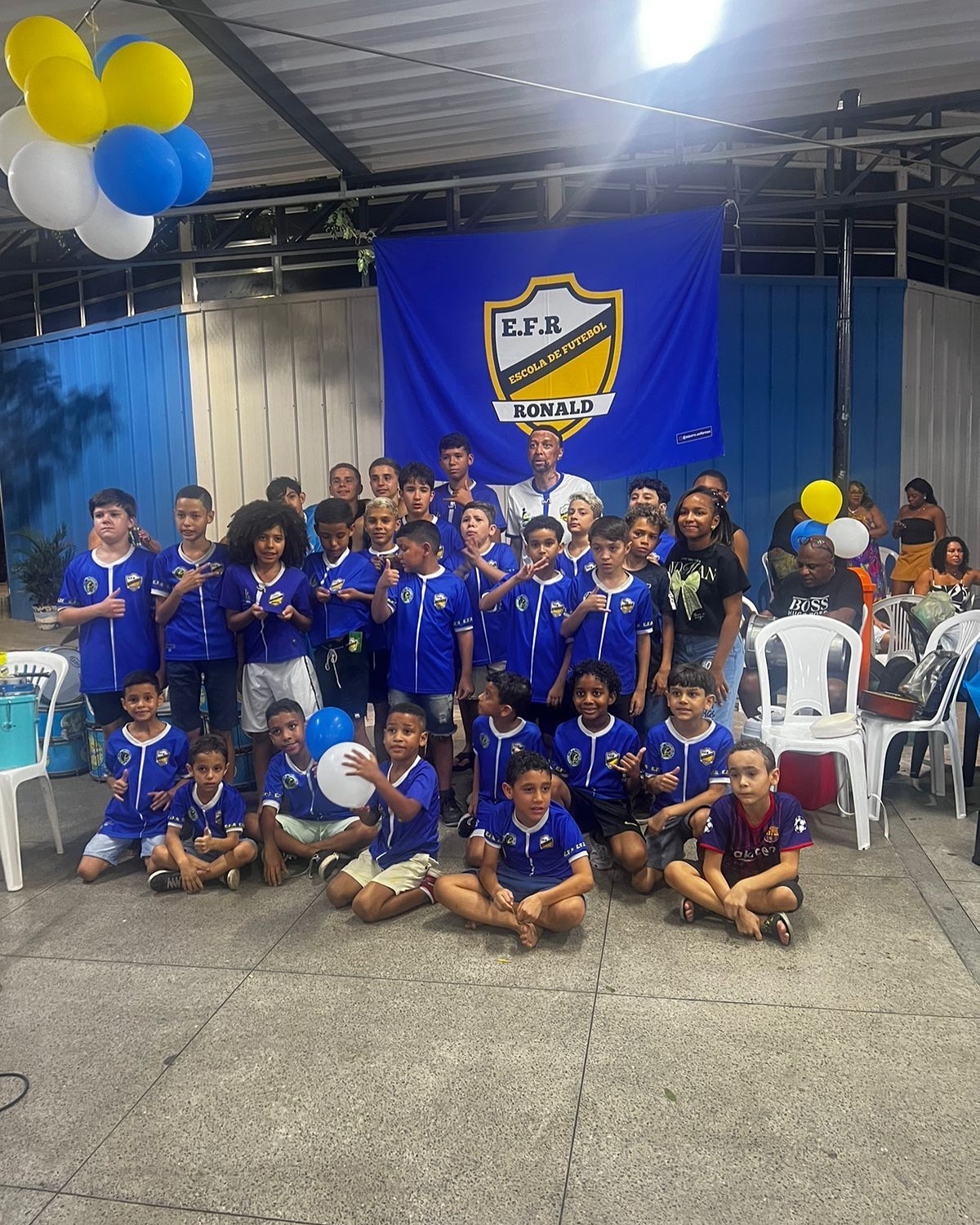Confraternização da escolinha com balões azuis e amarelos