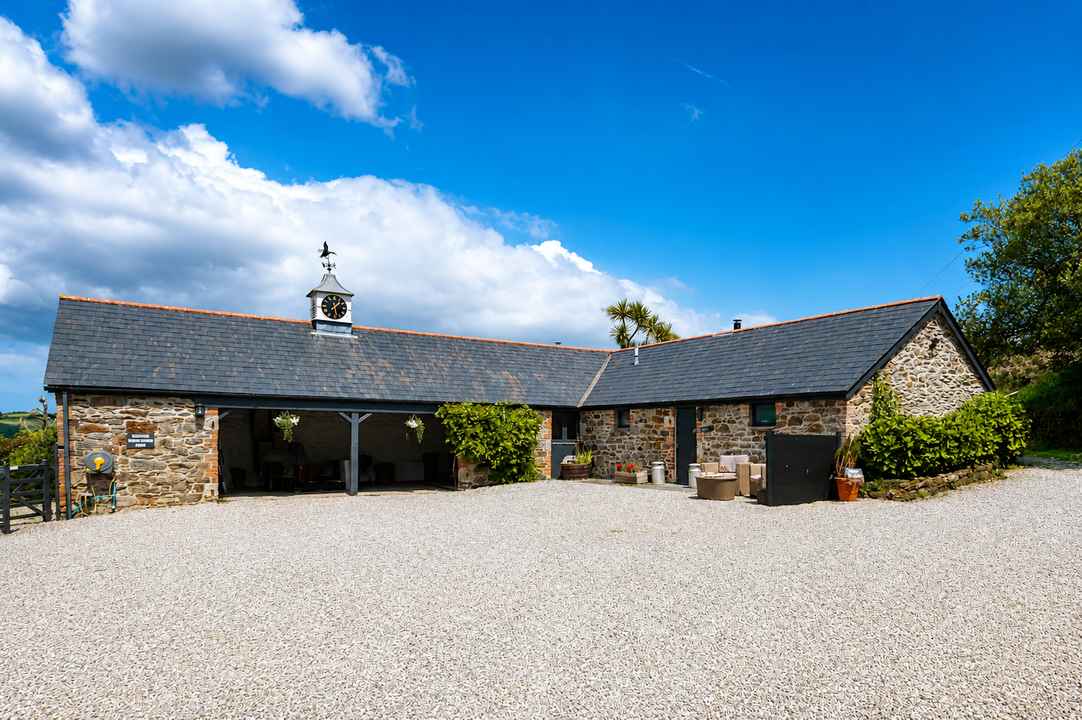 Stone barn with clock tower and gravel courtyard, Cornwall