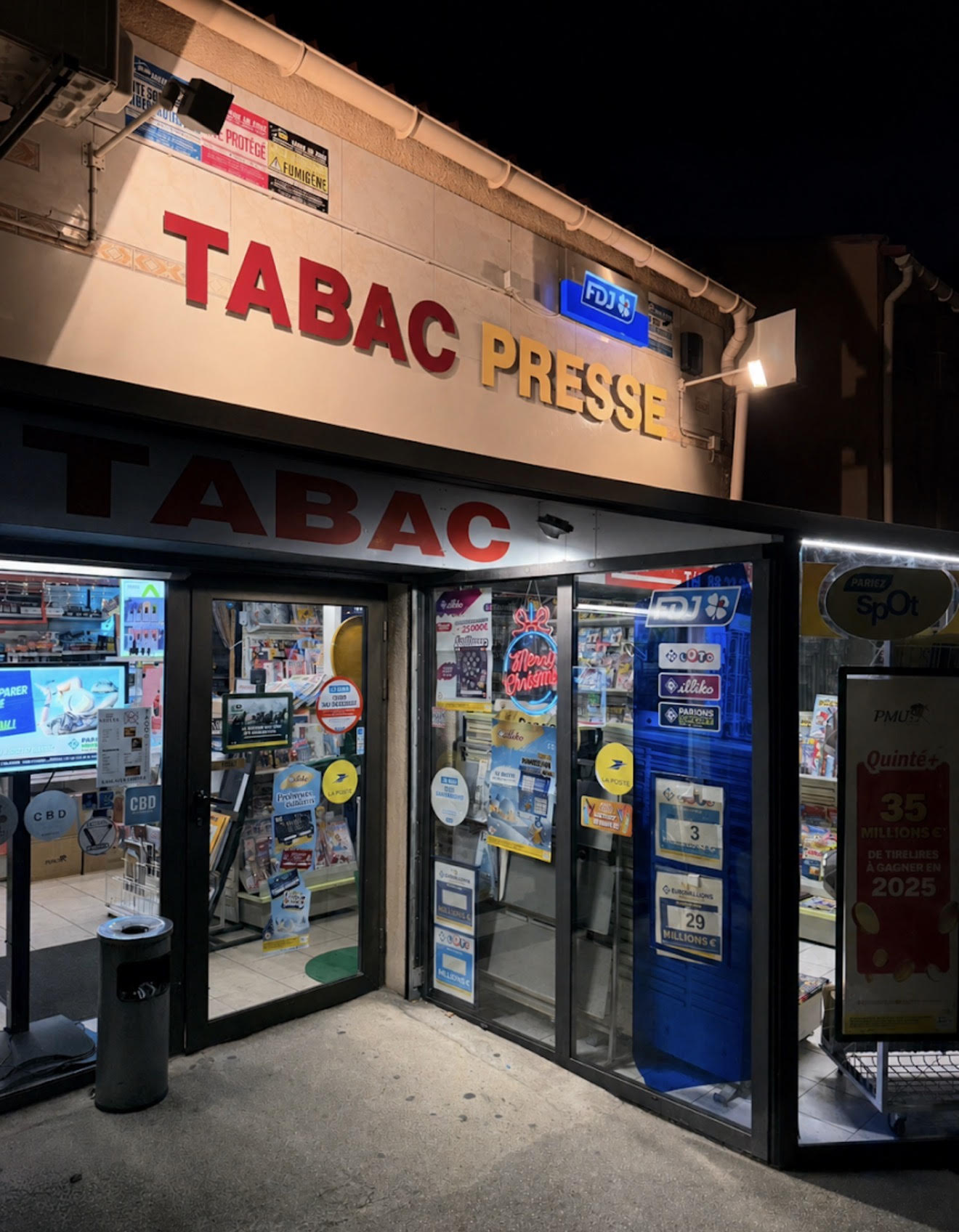 Façade illuminée de nuit avec enseignes TABAC PRESSE