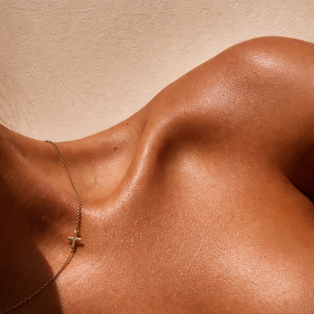 Bronze glow shoulder detail with delicate necklace
