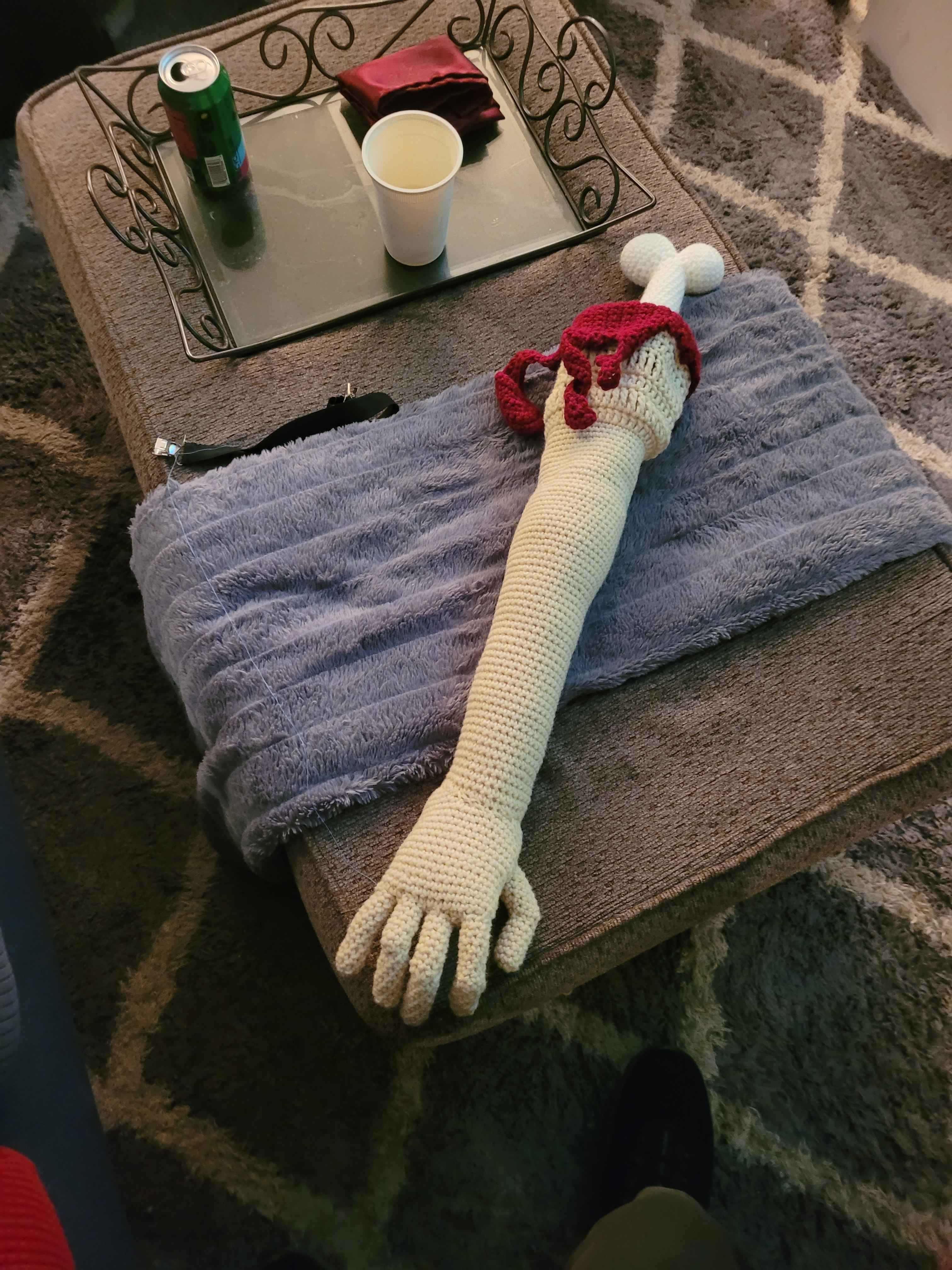 Full-length crocheted soft cosmetic arm with red details
