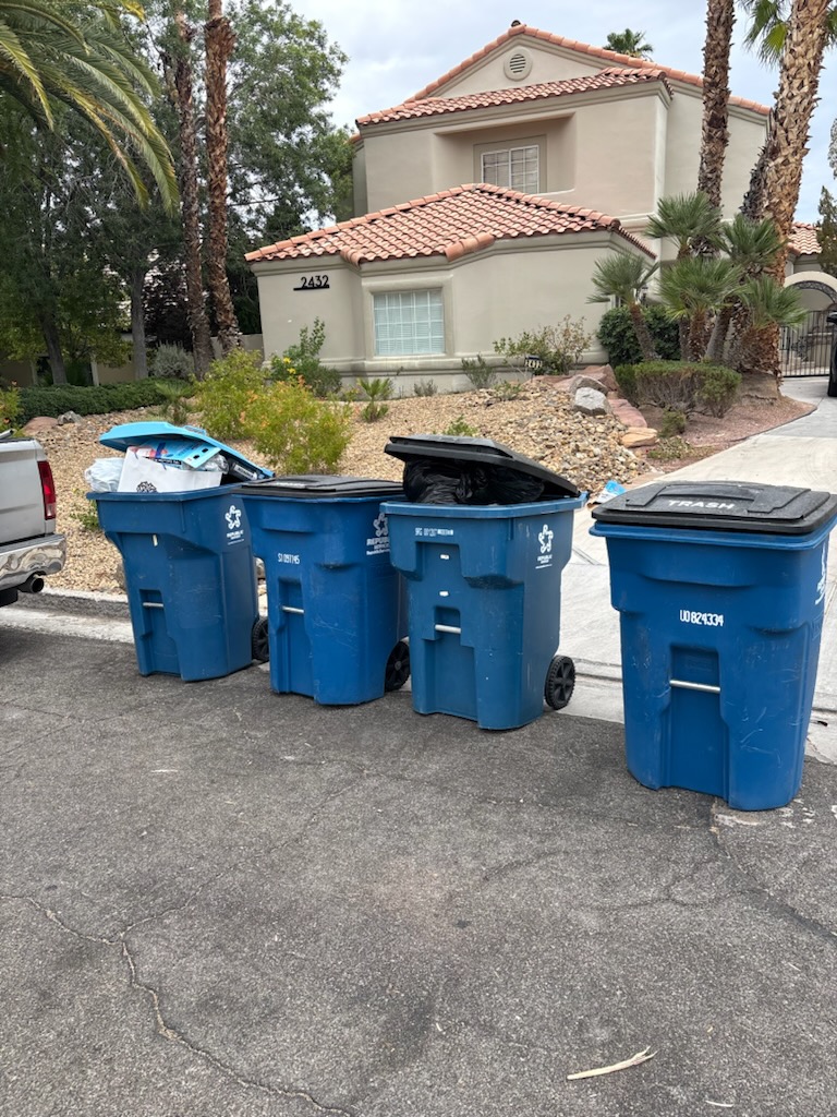 Several full residential trash and recycling bins lined up at a Las Vegas curb