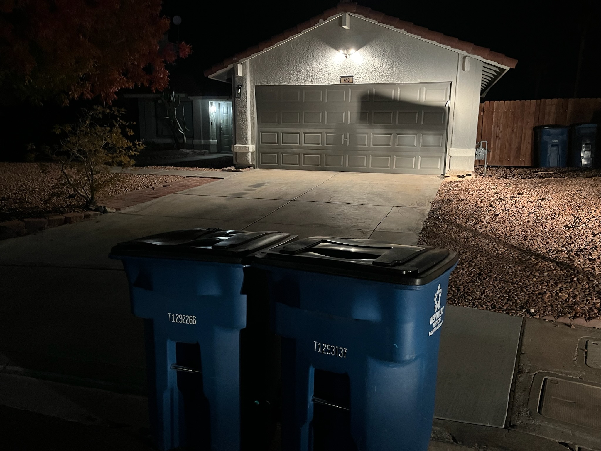 Residential trash bins staged at the curb outside a Las Vegas home at night