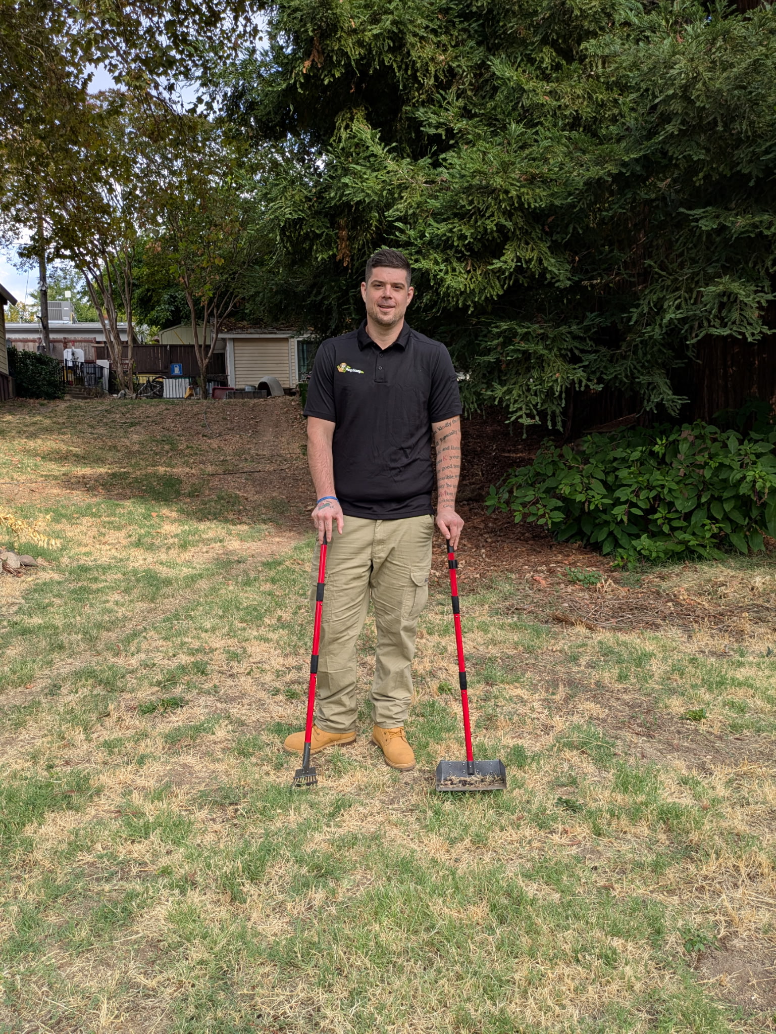 Poop Scoop Co. owner standing in a backyard with cleanup tools