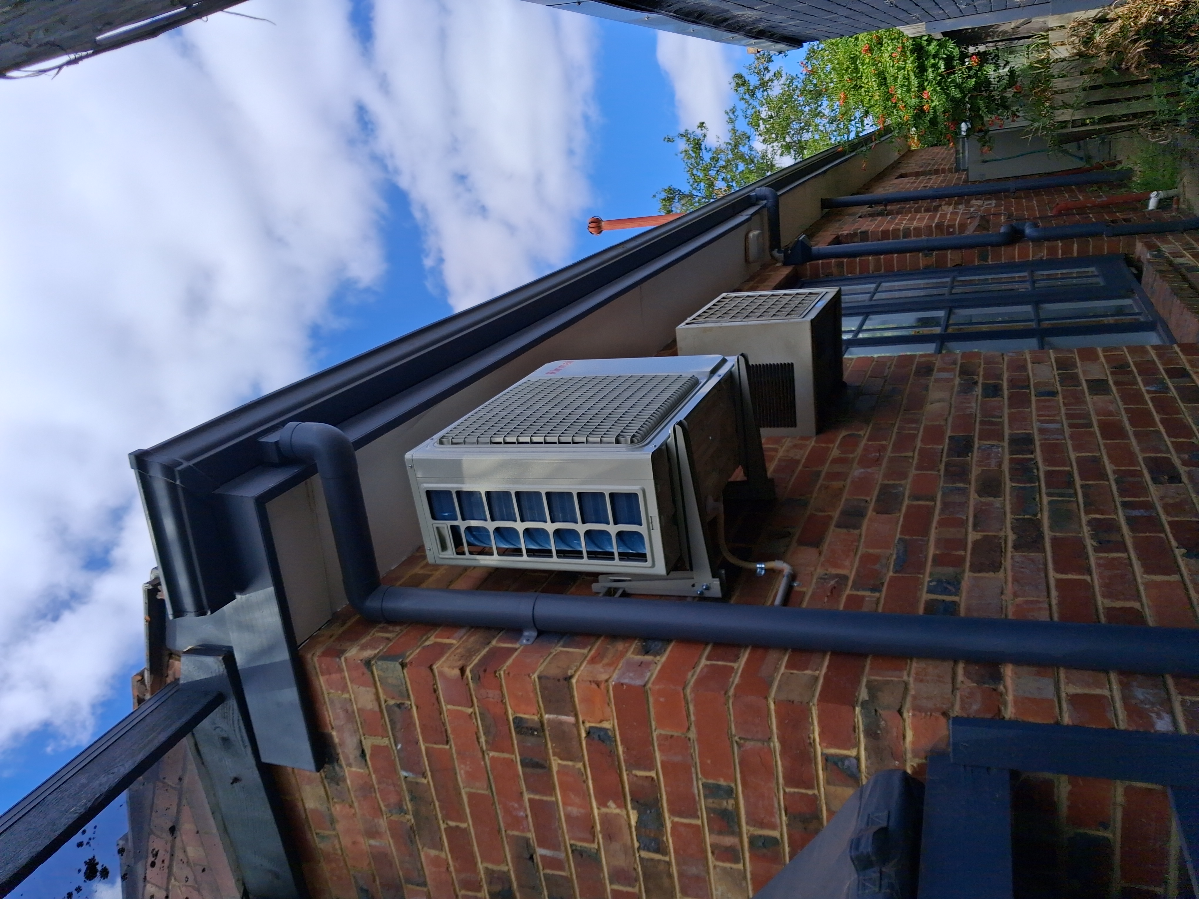 Evaporative cooler unit mounted on brick wall exterior
