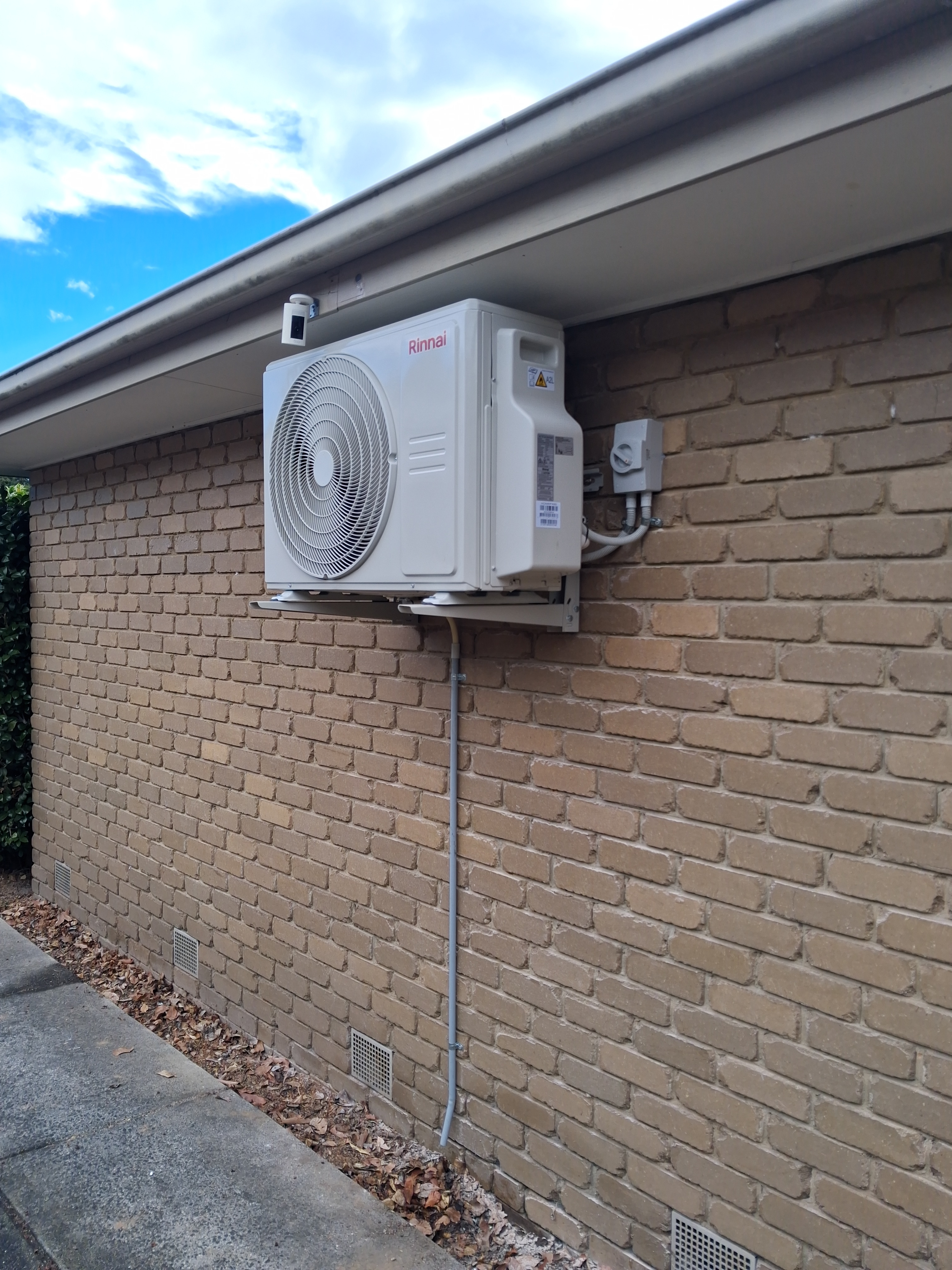 Rinnai outdoor condenser unit on brick wall