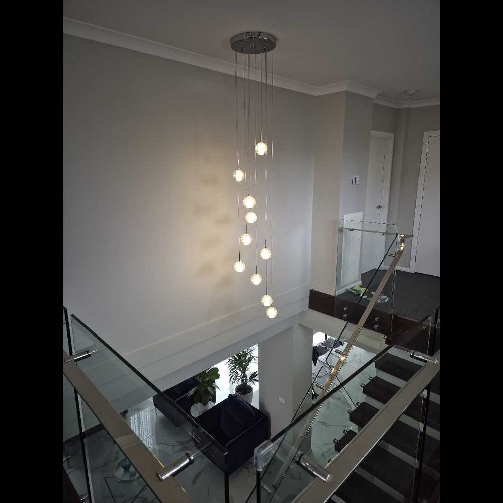 Modern pendant light fixture with glass globes in stairwell