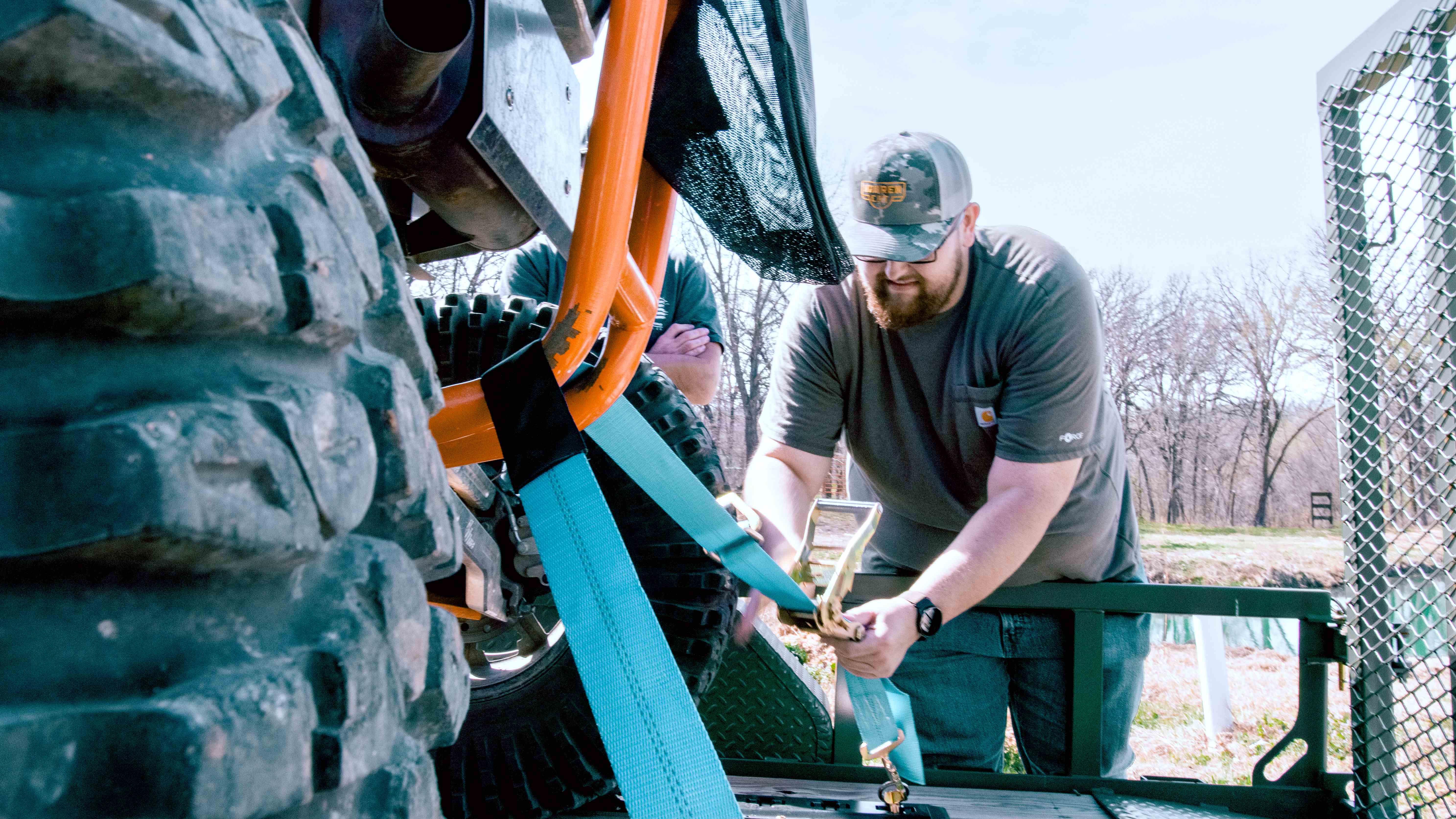 Prairie State Rentals crew member securing tie-down straps on a UTV