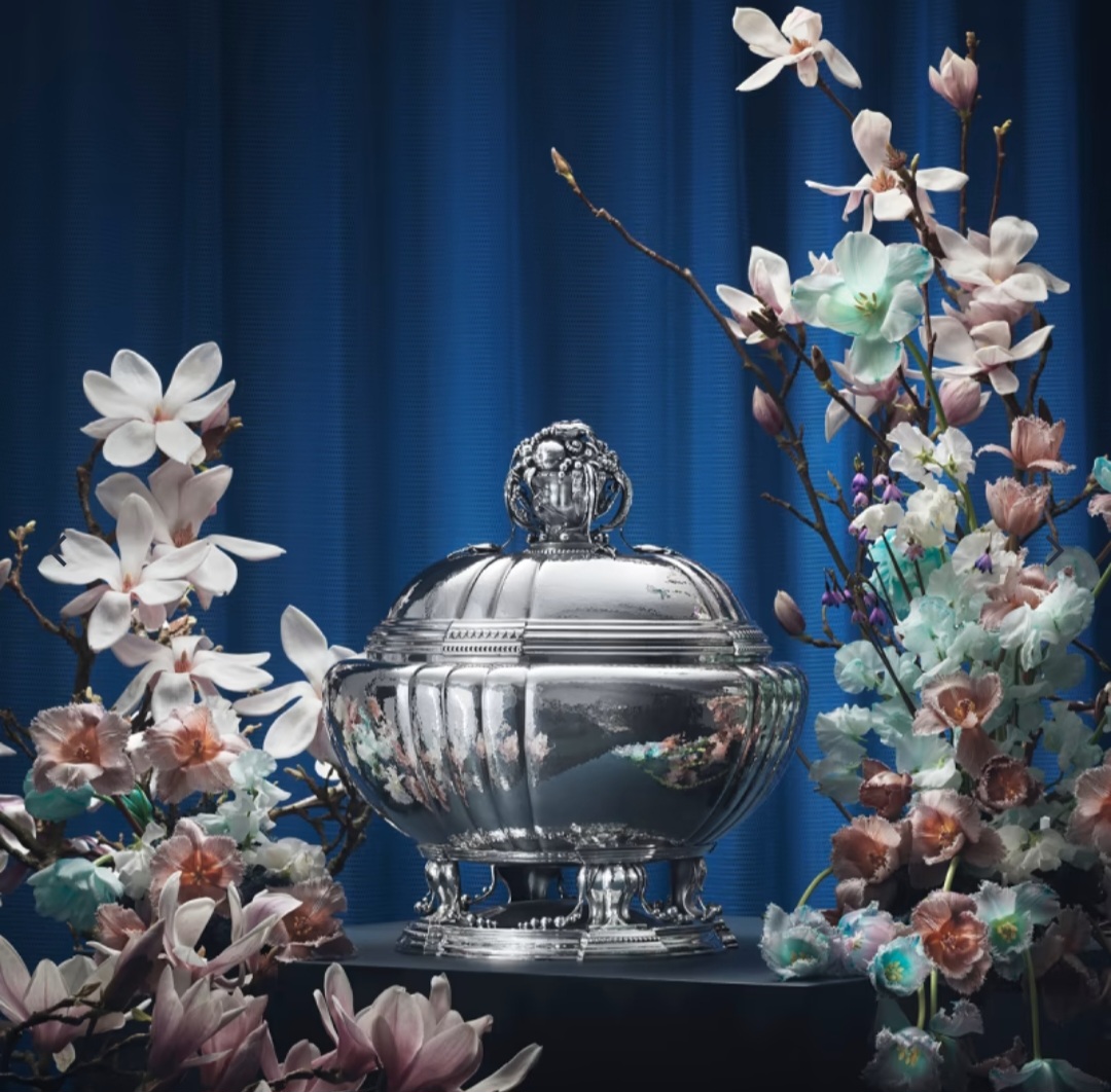 Sølvterrin iscenesat med blomster mod blå baggrund