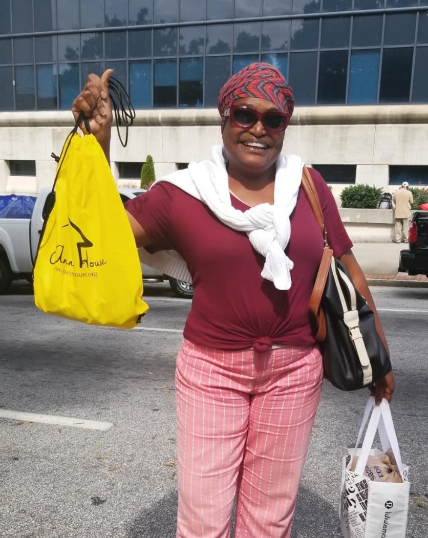 Community member holding a Jo-Anne's House bag outdoors