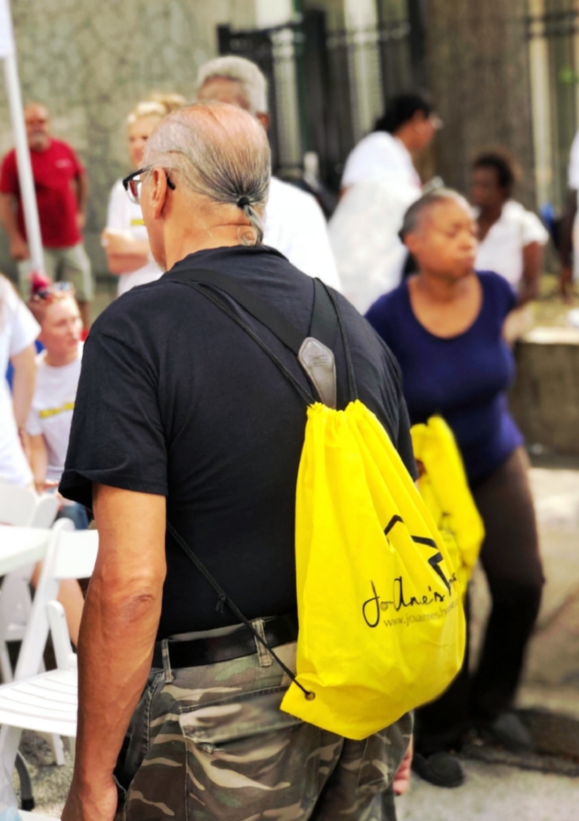 Community member carrying a Jo-Anne's House drawstring bag at outreach event