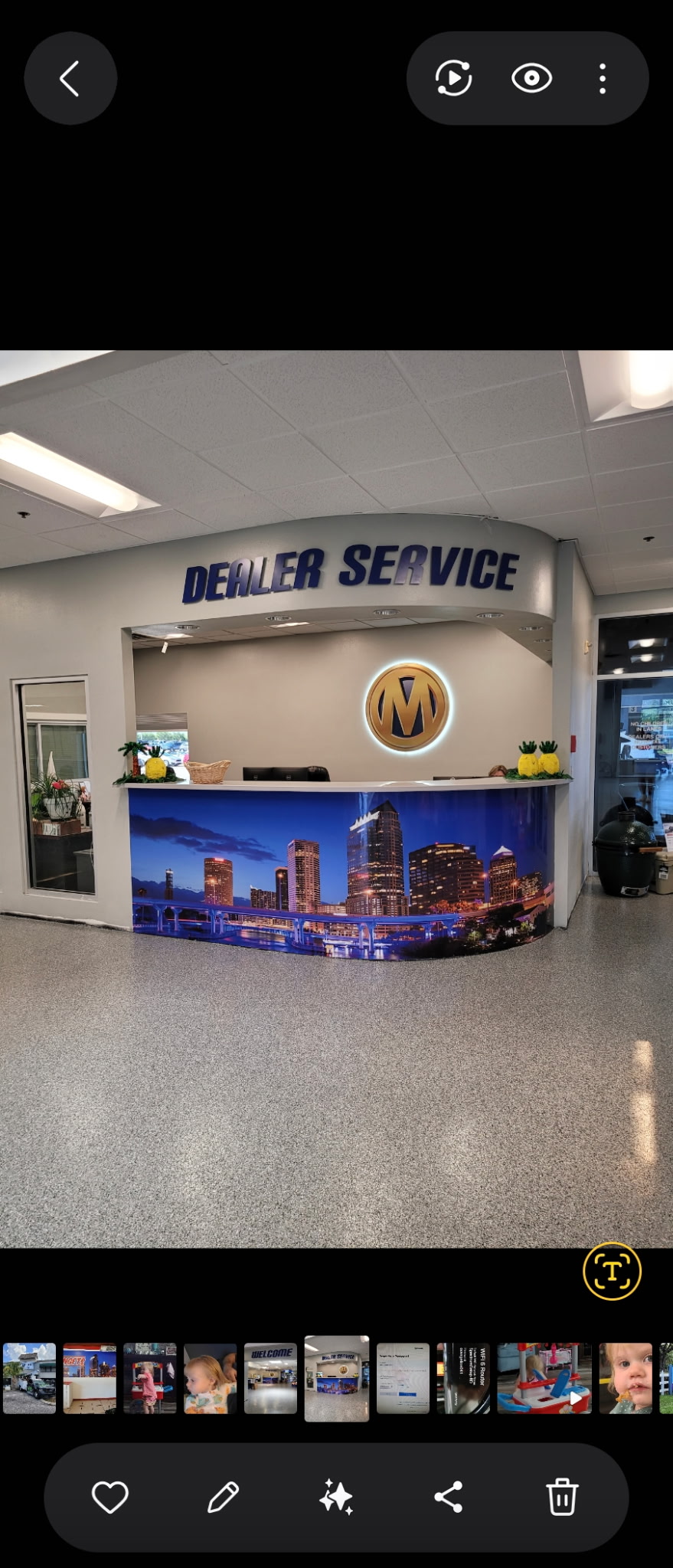 Dealer Service interior dark blue dimensional letters above curved service desk with backlit gold medallion