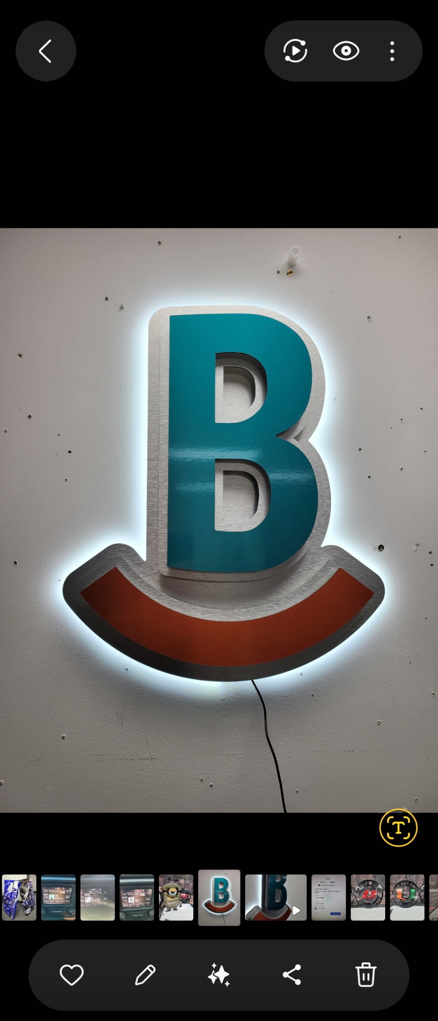 Backlit teal and brushed aluminum dimensional letter B with halo glow