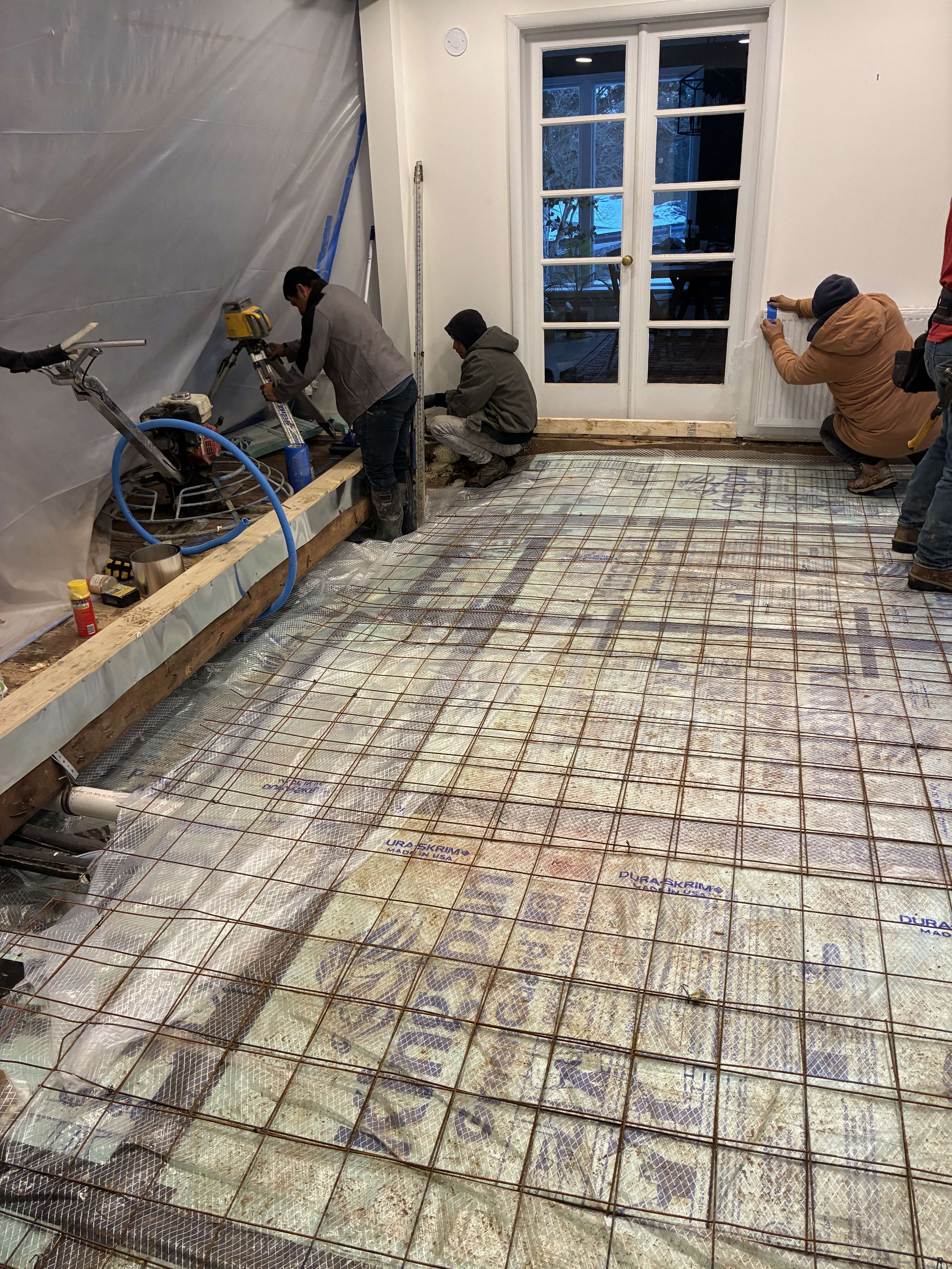 Crew preparing residential floor pour with rebar