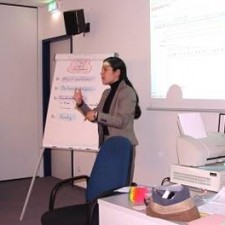Frau referiert am Flipchart vor Beamer-Projektion