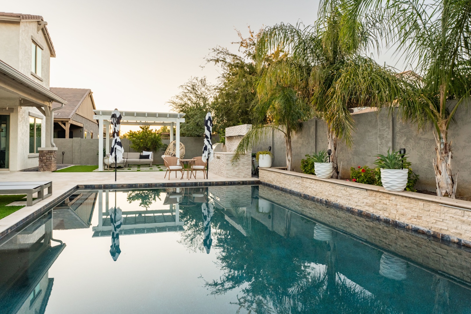 Pool side-angle with palms, planters, and travertine deck — Comstock Dr
