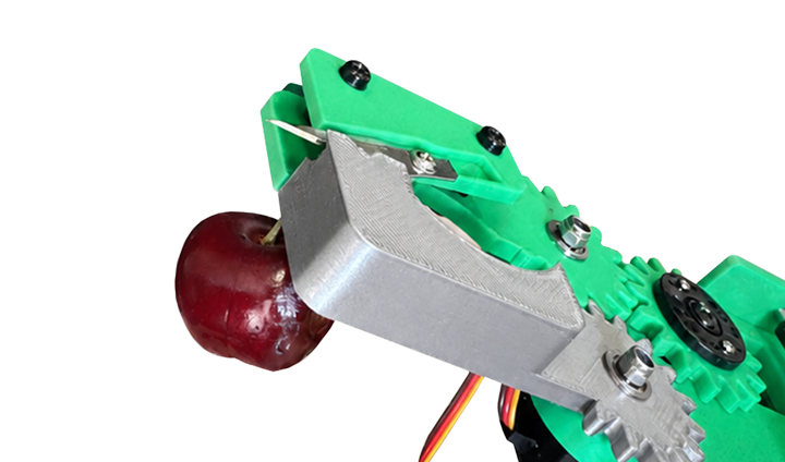 Snipit gripper holding cherry on black background demonstrating precise manipulation
