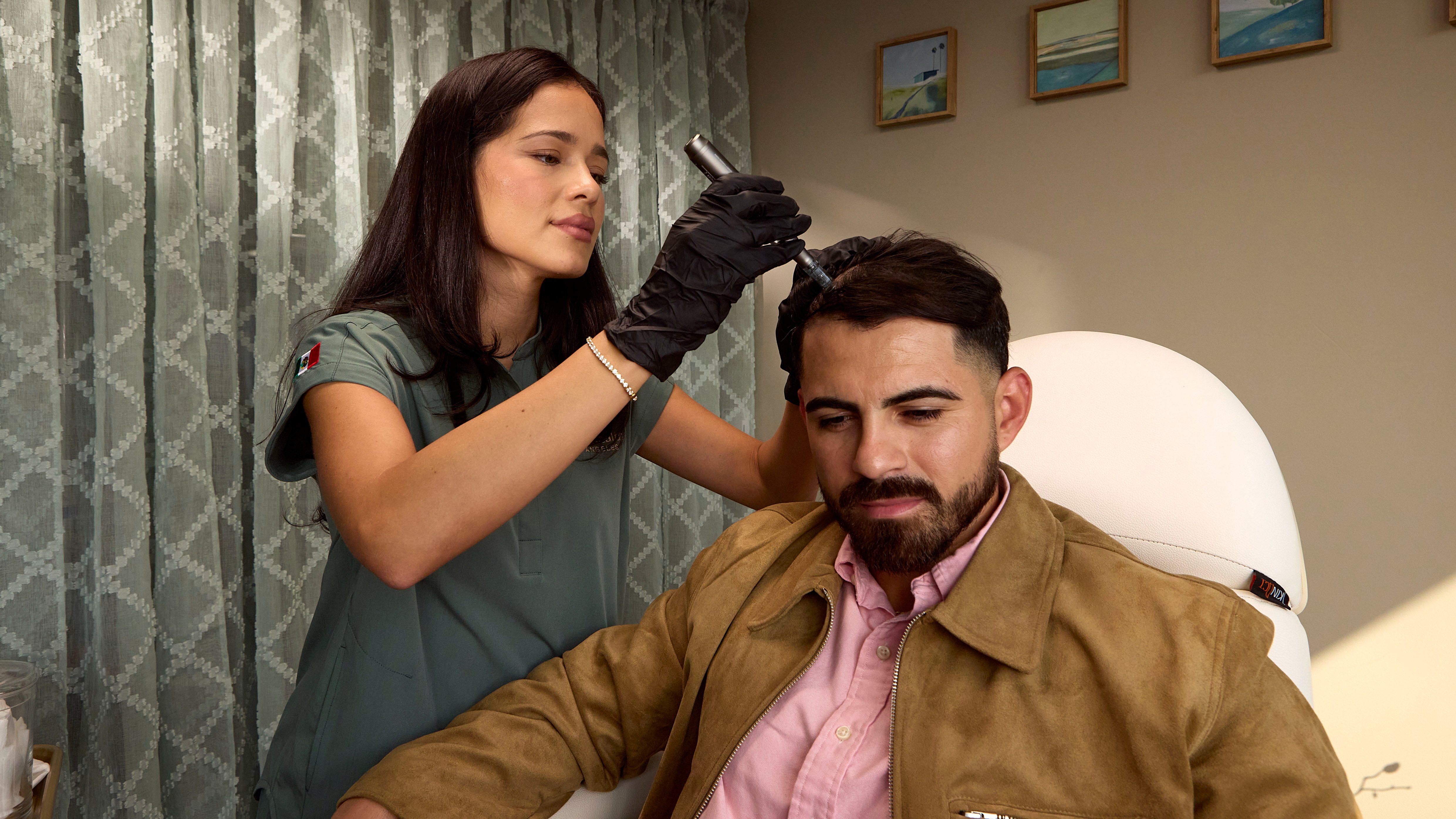 Clinician performing a hair restoration treatment with a handheld device
