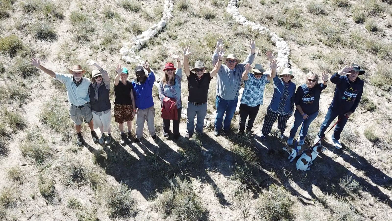 Group celebrating on geoglyph with arms raised
