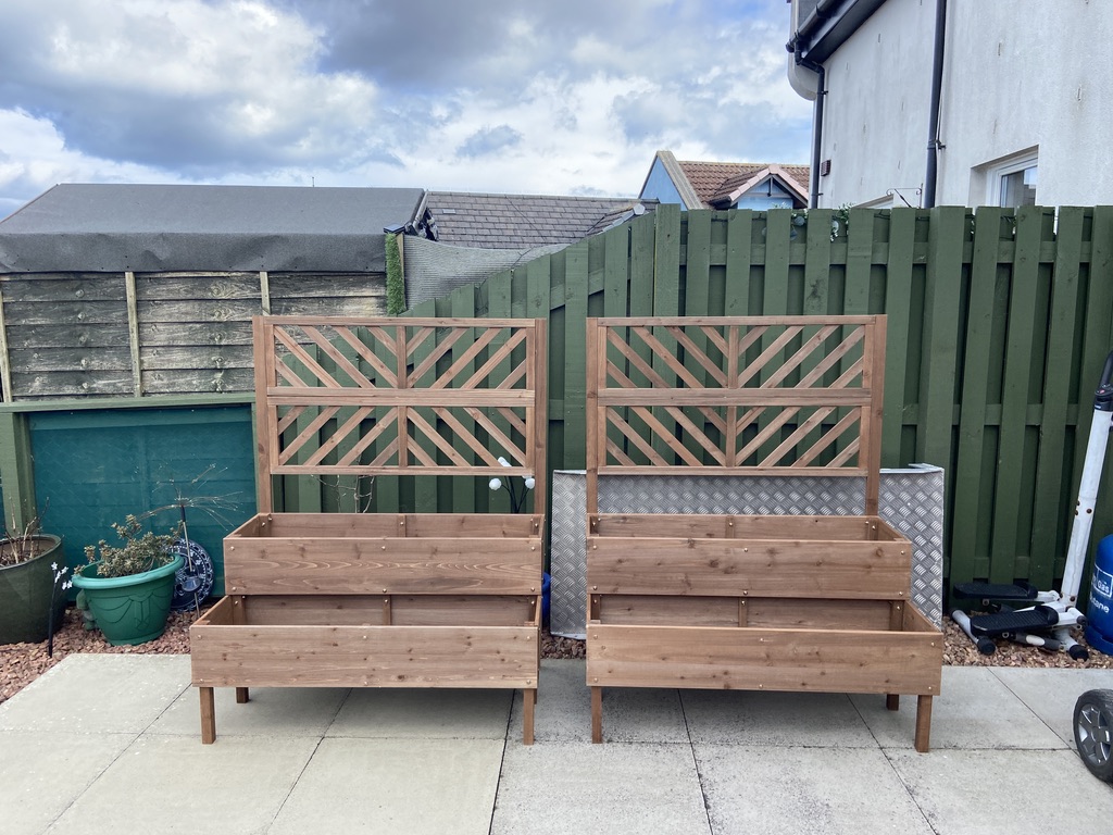 Handcrafted wooden raised planters with diagonal lattice trellis on jet-washed paving