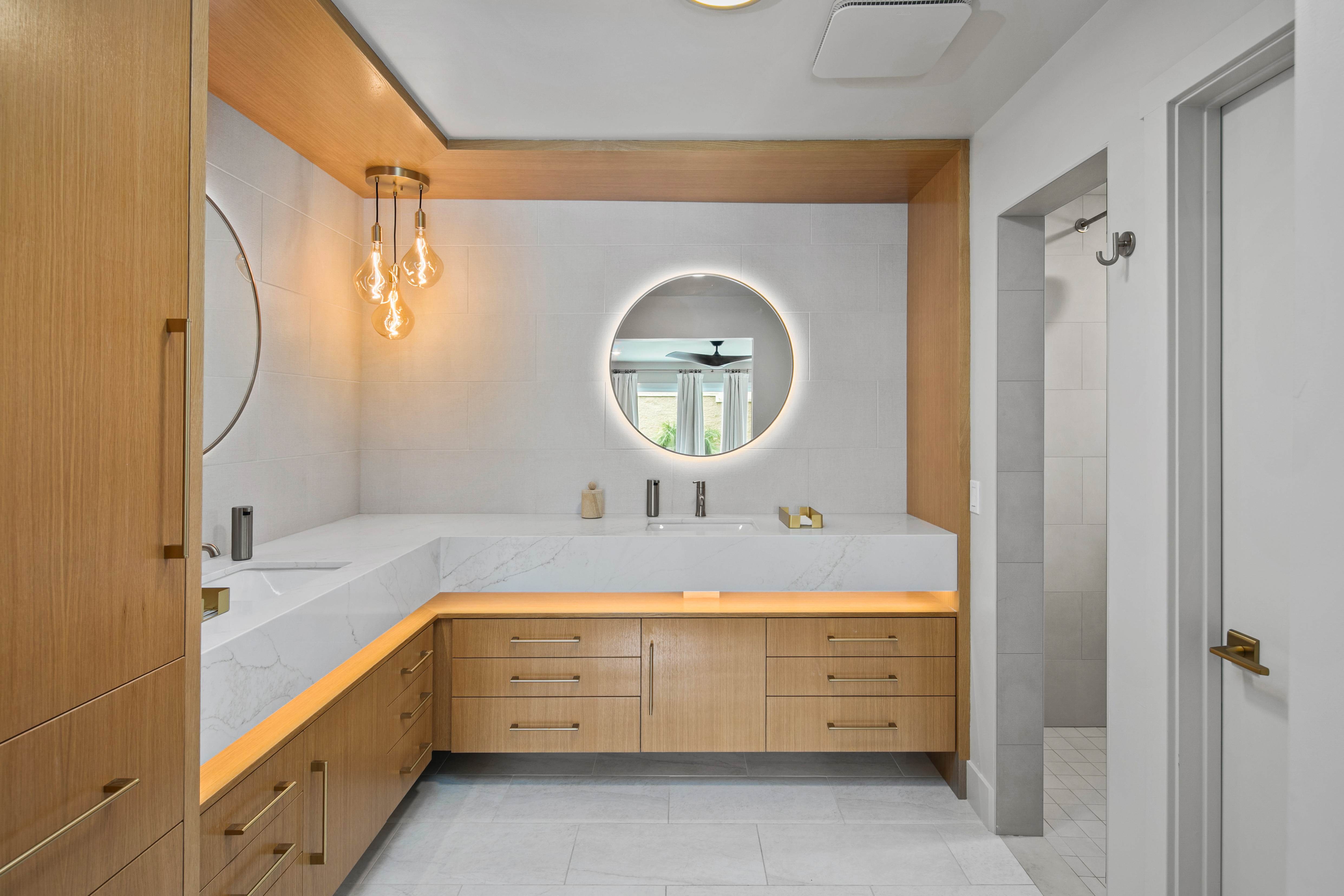 Spa-inspired bathroom with marble counters and warm pendant lighting