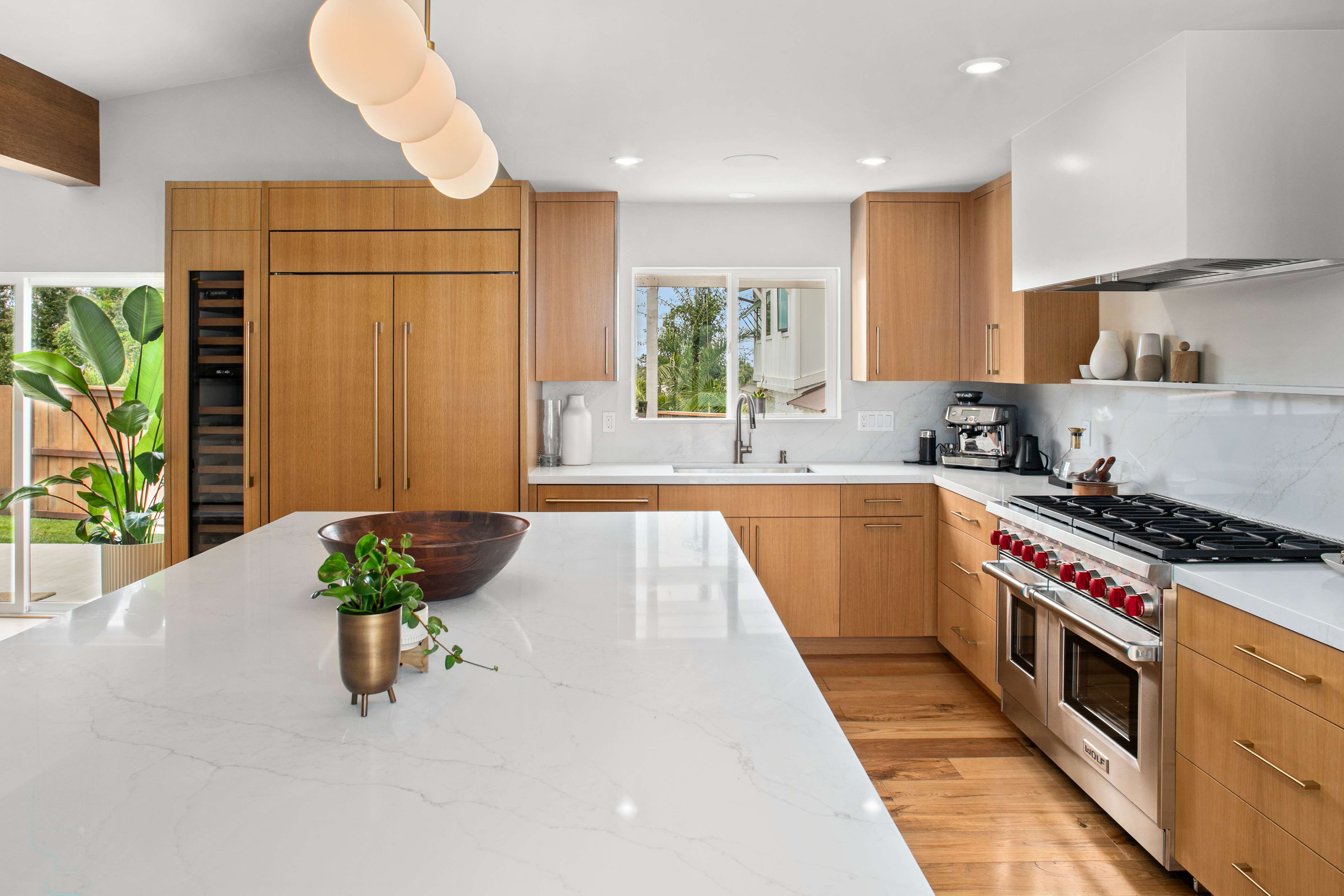 Luxury kitchen remodel with warm oak cabinetry and quartz island